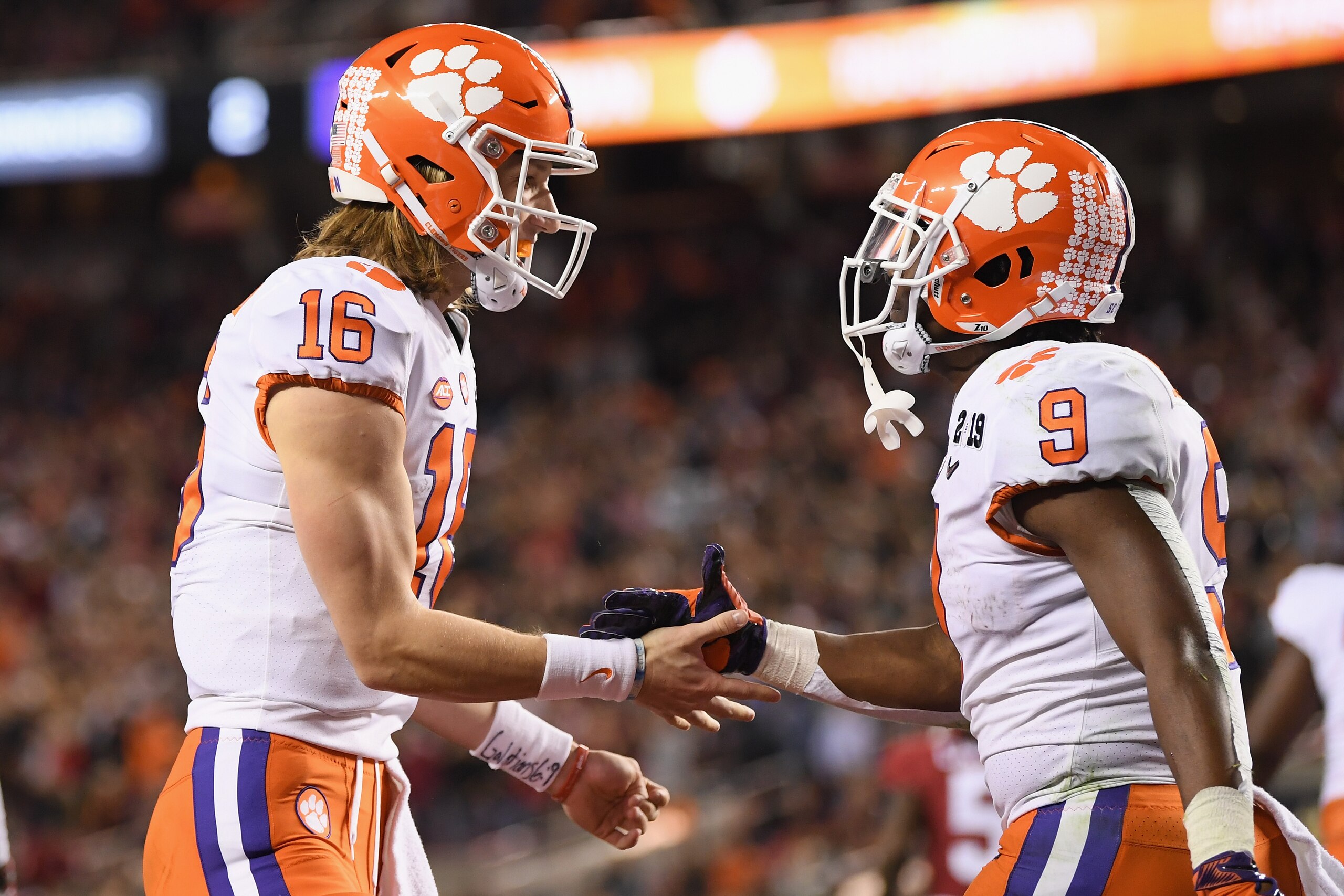 SANTA CLARA, CA - JANUARY 07:  Trevor Lawrence #16 and Travis Etienne #9 of the Clemson Tigers celebrate their second quarter touchdown against the Alabama Crimson Tide in the CFP National Championship presented by AT&T at Levi's Stadium on January 7, 201