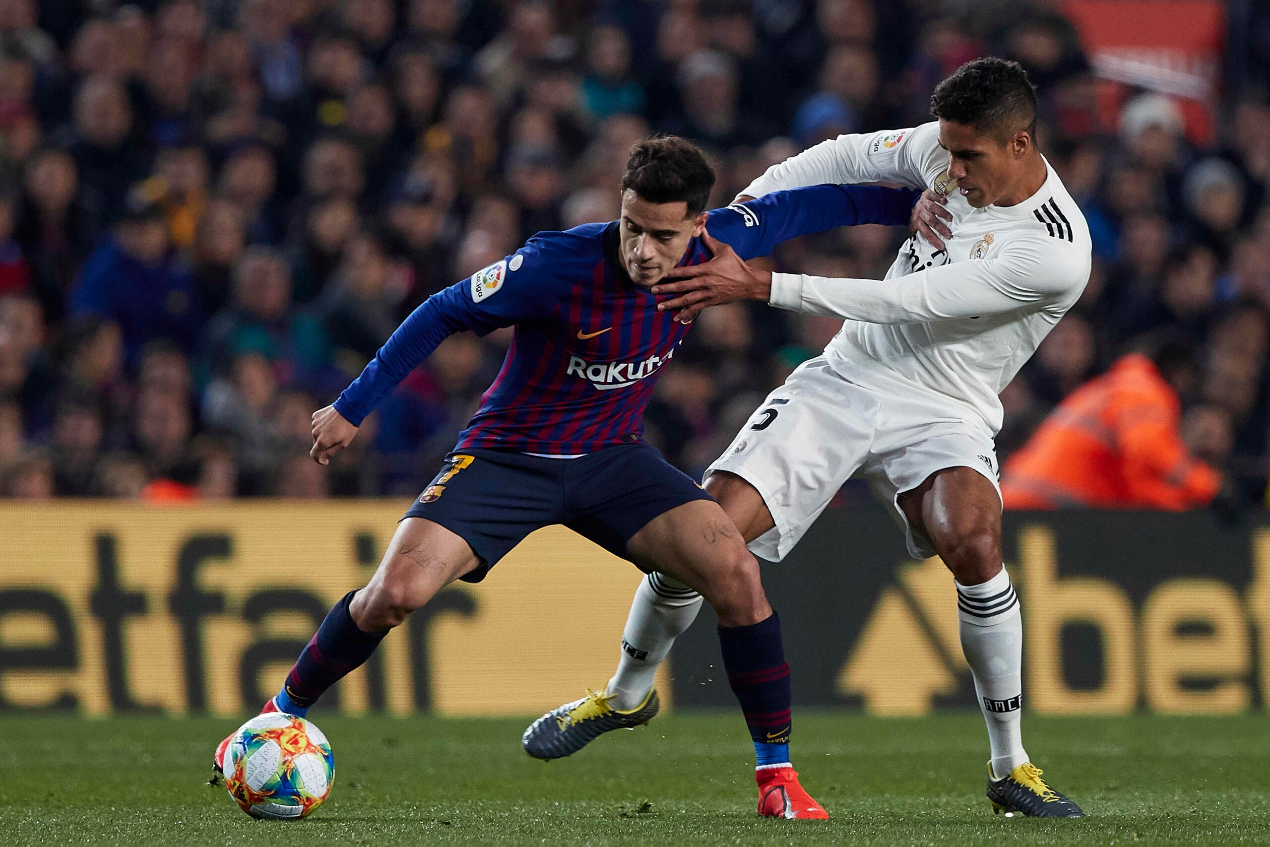 BARCELONA, SPAIN - FEBRUARY 06: Philippe Coutinho of FC Barcelona competes for the ball with Raphael Varane of Real Madrid during the Copa del Rey Semi Final first leg match between FC Barcelona and Real Madrid at Nou Camp on February 06, 2019 in Barcelon