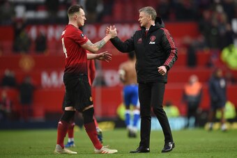 Manchester United's  Norwegian caretaker manager Ole Gunnar Solskjaer (R) greets Manchester United's English defender Phil Jones (L) at the end of the English FA Cup third round football match between Manchester United and Reading at Old Trafford in Manch