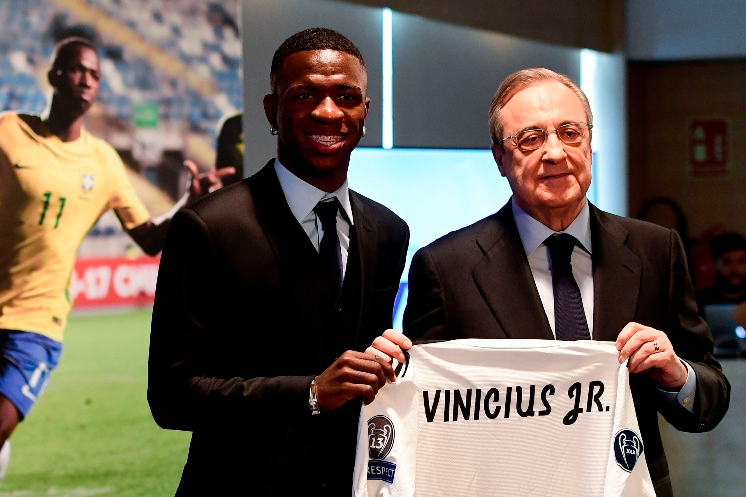 Real Madrid's new Brazilian forward Vinicius Junior (L) holds his new jersey as he poses with Real Madrid president Florentino Perez during his official presentation at the Santiago Bernabeu Stadium in Madrid on July 20, 2018. (Photo by PIERRE-PHILIPPE MA