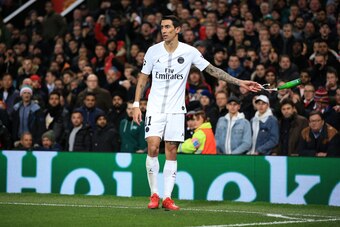 MANCHESTER, ENGLAND - FEBRUARY 12:  Angel Di Maria of Paris Saint-Germain tosses away a bottle of beer thrown by the fans during the UEFA Champions League Round of 16 First Leg match between Manchester United and Paris Saint-Germain at Old Trafford on Feb