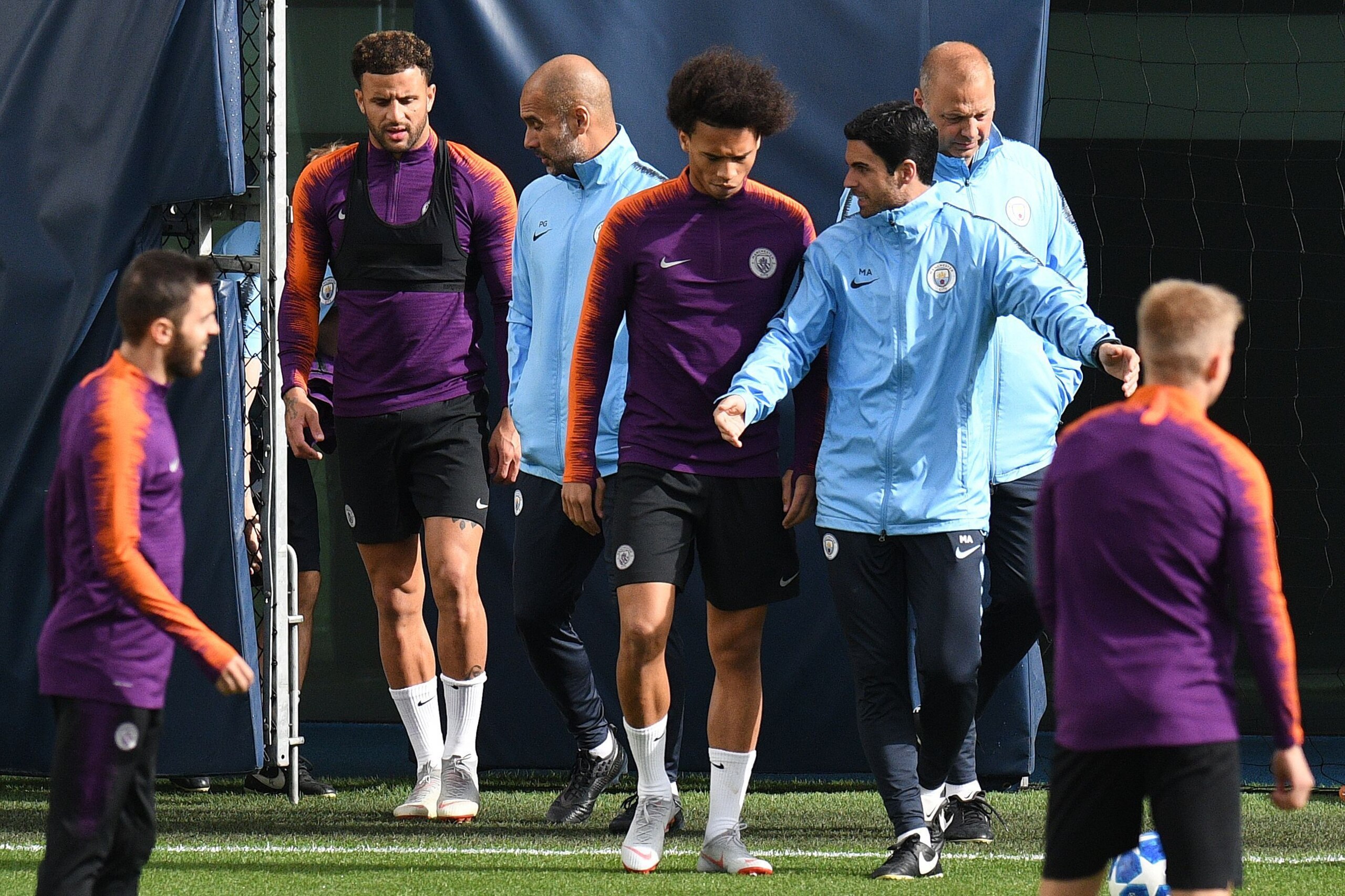 Manchester City's English defender Kyle Walker (2L), Manchester City's Spanish manager Pep Guardiola (C), Manchester City's German midfielder Leroy Sane (centre R), and Spanish assitant coach Mikel Arteta (3R) attend a training session at City Football Ac
