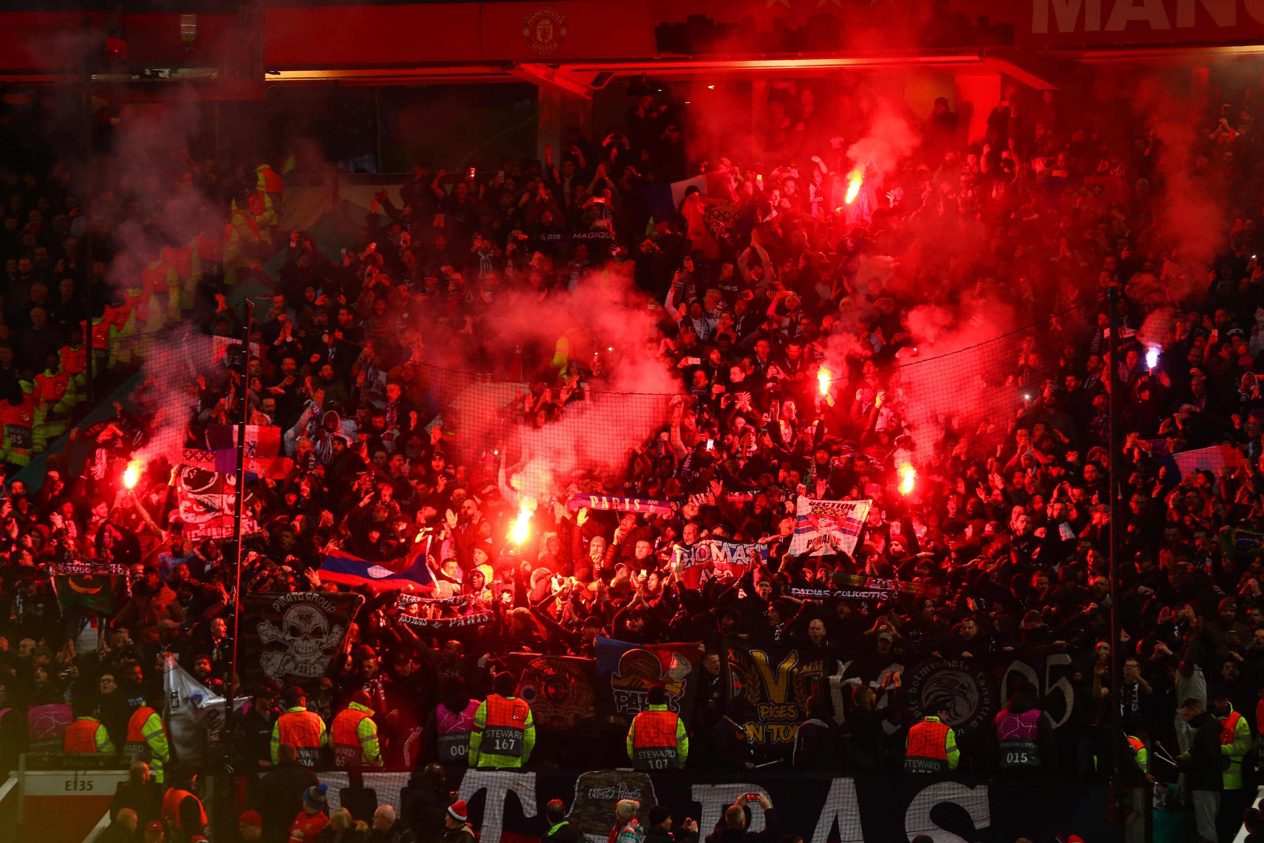 MANCHESTER, ENGLAND - FEBRUARY 12: Paris Saint-Germain fans light flares prior to the UEFA Champions League Round of 16 First Leg match between Manchester United and Paris Saint-Germain at Old Trafford on February 12, 2019 in Manchester, England. (Photo MANCHESTER, ENGLAND - FEBRUARY 12: Paris Saint-Germain fans light flares prior to the UEFA Champions League Round of 16 First Leg match between Manchester United and Paris Saint-Germain at Old Trafford on February 12, 2019 in Manchester, England. (Photo
