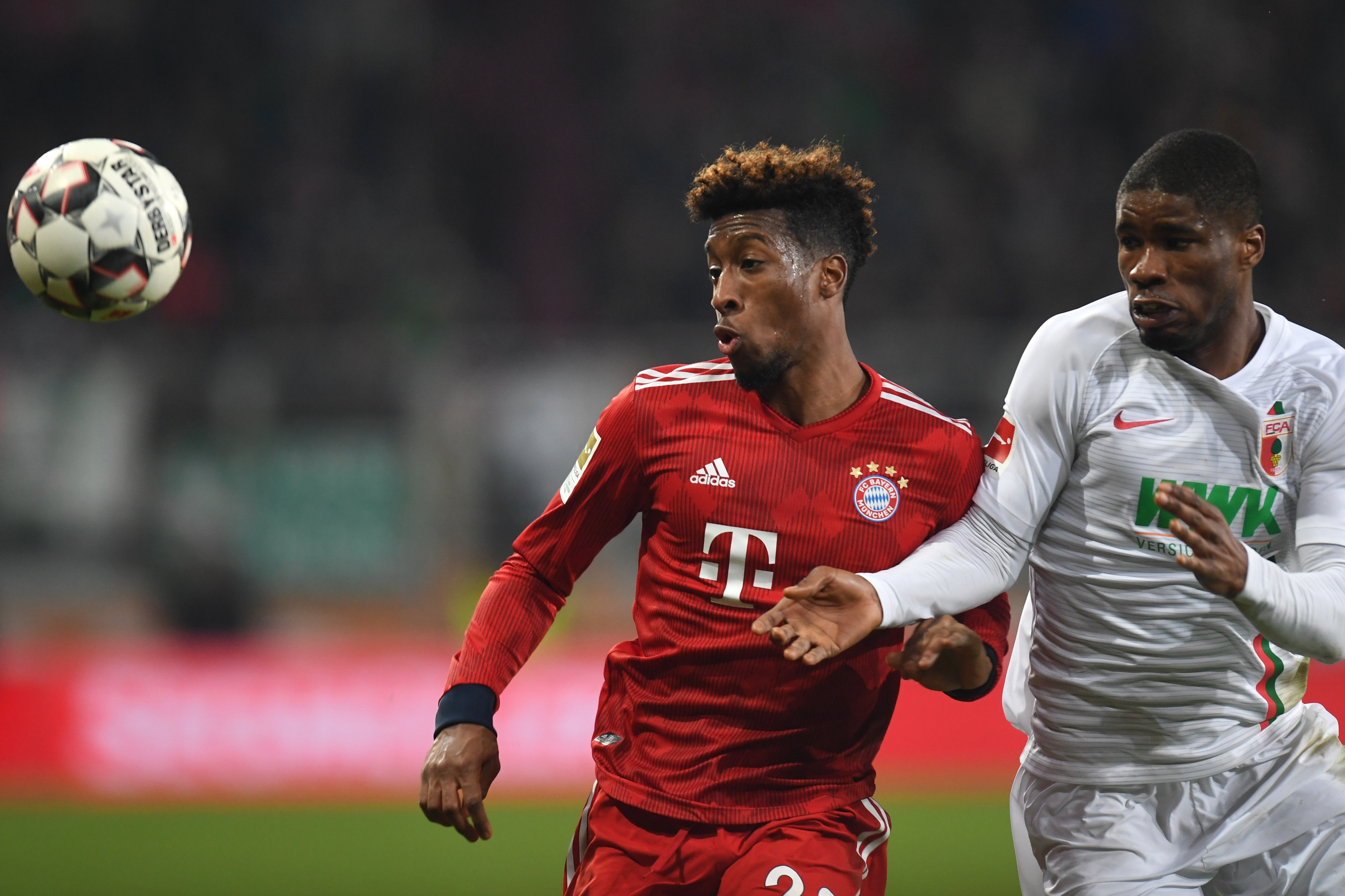 Bayern Munich's French defender Kingsley Coman (L) and Augsburg's Austrian defender Kevin Danso vie for the ball during the German first division Bundesliga match between FC Augsburg and FC Bayern Munich in Augsburg, southern Germany, on February 15, 2019
