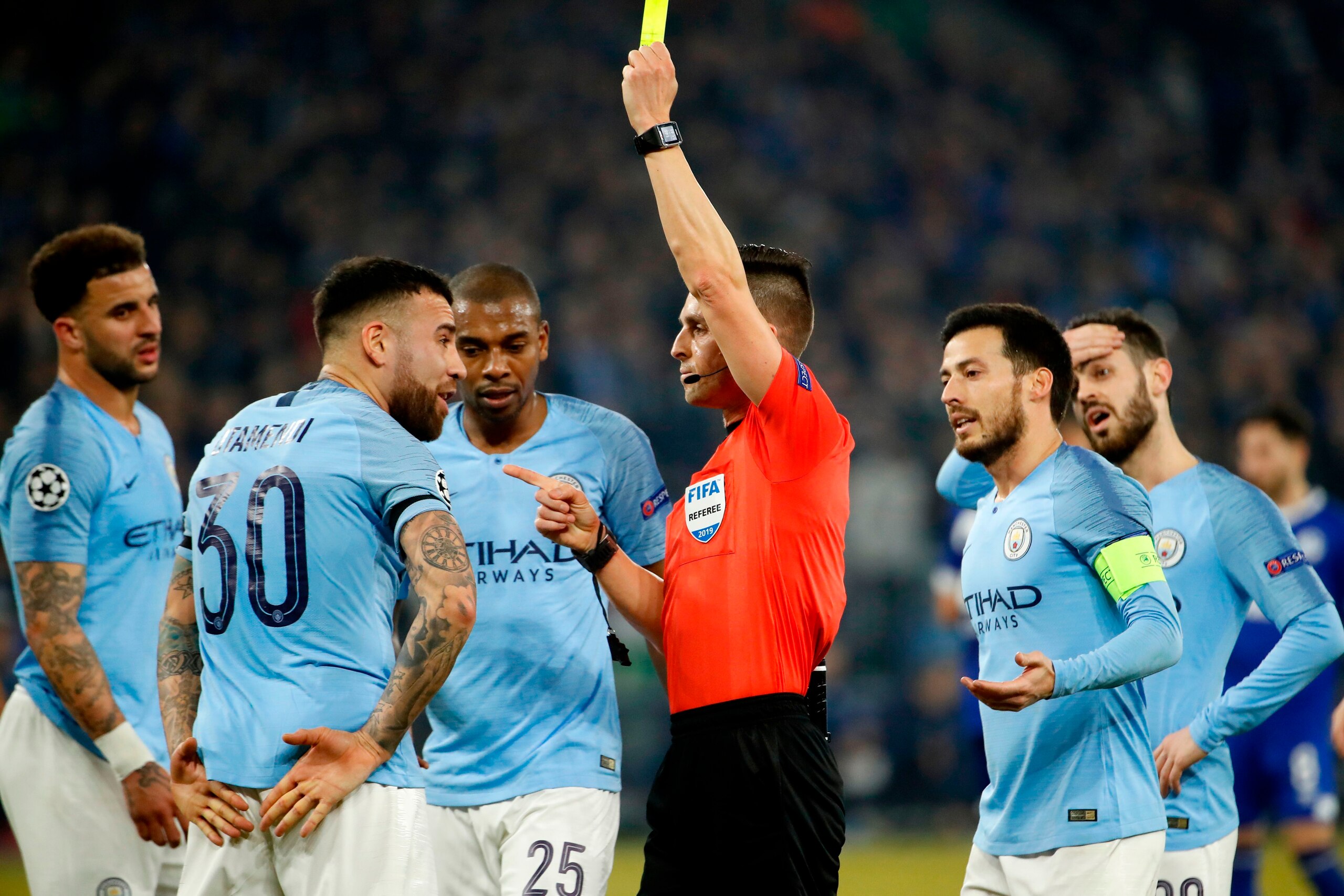 Spanish Referee Carlos Del Cerro Grande shows a yellow card to Manchester City's Argentine defender Nicolas Otamendi during the UEFA Champions League round of 16 first leg football match between Schalke 04 and Manchester City on February 20, 2019 in Gels Spanish Referee Carlos Del Cerro Grande shows a yellow card to Manchester City's Argentine defender Nicolas Otamendi during the UEFA Champions League round of 16 first leg football match between Schalke 04 and Manchester City on February 20, 2019 in Gels