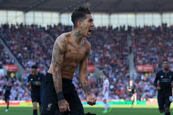 Liverpool's Brazilian midfielder Roberto Firmino (L) celebrates scoring his team's second goal during the English Premier League football match between Stoke City and Liverpool at the Bet365 Stadium in Stoke-on-Trent, central England on April 8, 2017. / A