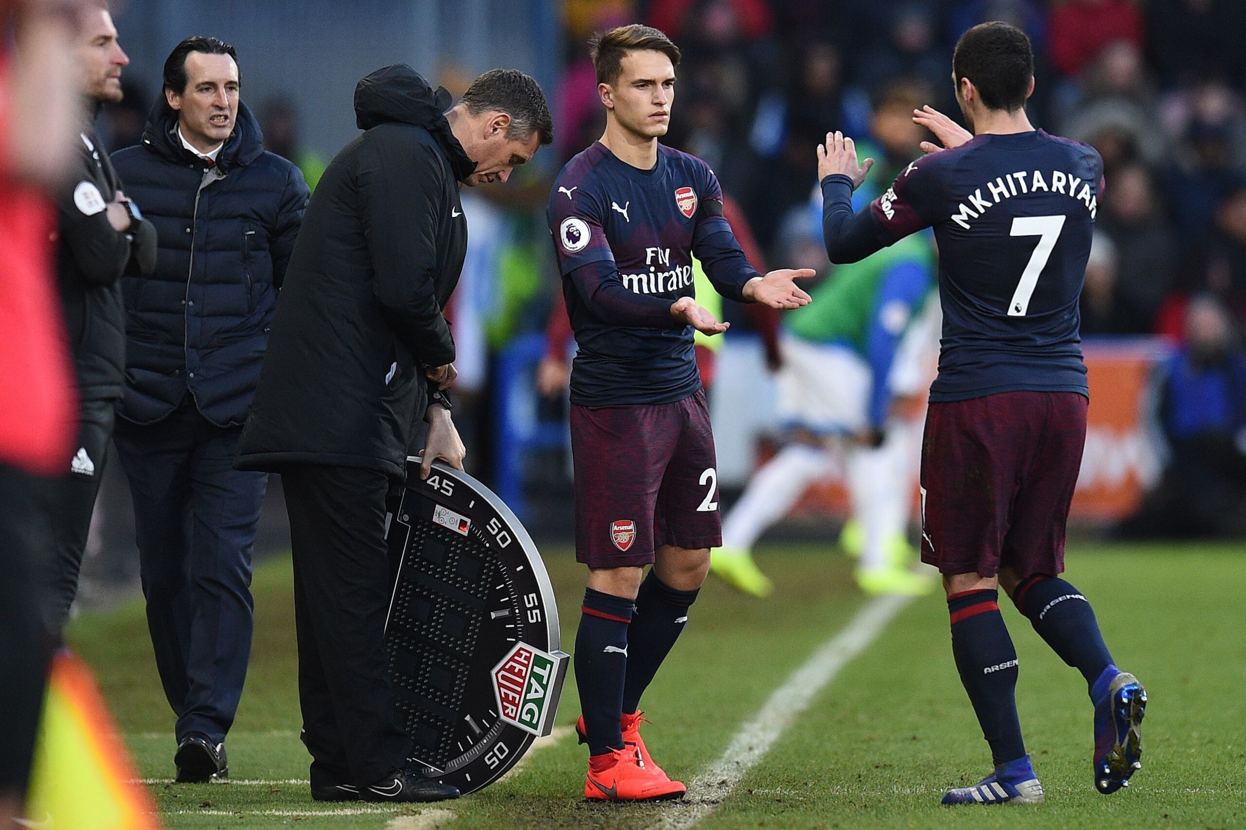 Arsenal's Spanish head coach Unai Emery (L) watches as Arsenal's Armenian midfielder Henrikh Mkhitaryan (R) leaves the pitch after being substituted off for Arsenal's Spanish midfielder Denis Suarez during the English Premier League football match between