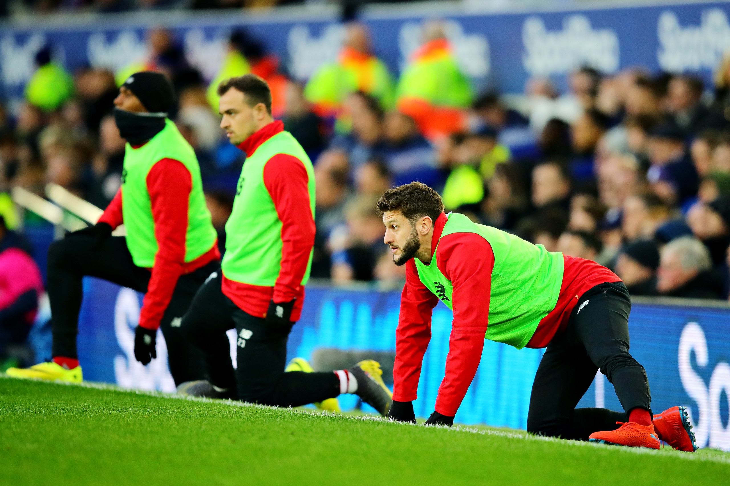 LIVERPOOL, ENGLAND - MARCH 03: Adam Lallana of Liverpool and teammates warm up on the sidelines during the Premier League match between Everton FC and Liverpool FC at Goodison Park on March 03, 2019 in Liverpool, United Kingdom. (Photo by Chris Brunskill/