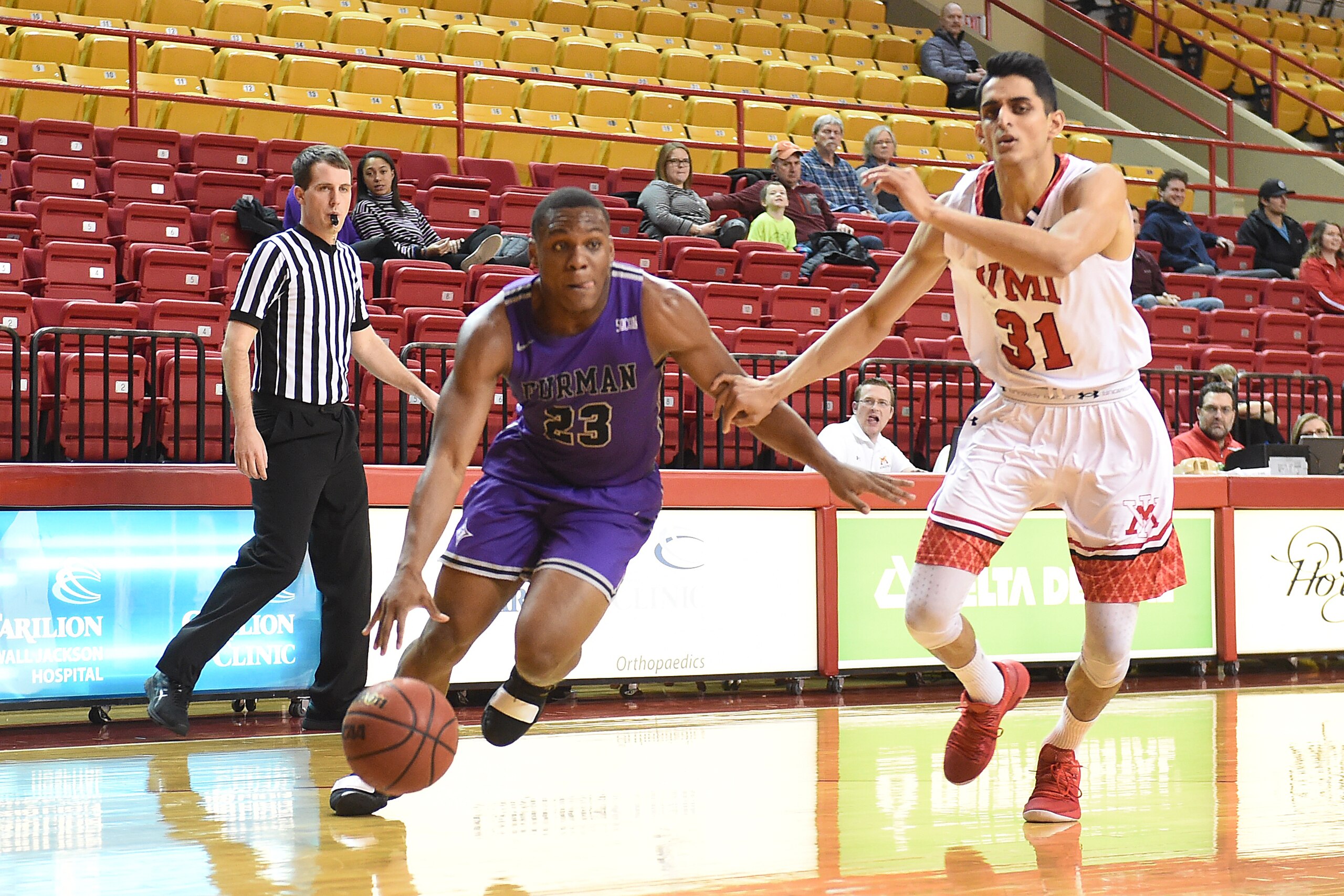 LEXINGTON, VA - JANUARY 10:  Jordan Lyons #23 of the Furman Paladins dribbles the ball by Sarju Patel #31 of the Virginia Military Keydets during a college basketball game at Cameron Hall on January 10, 2019 in Lexington, Virginia.  (Photo by Mitchell Lay