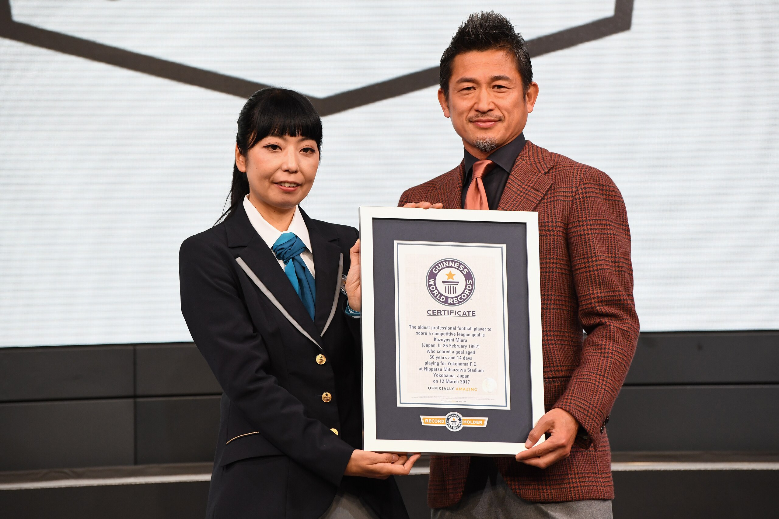 TOKYO, JAPAN - FEBRUARY 15:  (EDITORIAL USE ONLY) Kazuyoshi Miura receives the Guinness World Record certificate as he is recognised as the 'Oldest professional football player to score a competitive league goal' during the J.League Kick Off Conference on