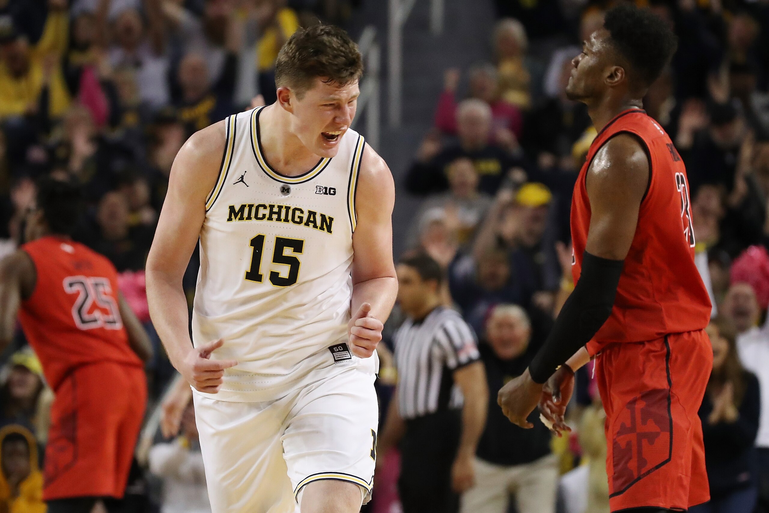 ANN ARBOR, MICHIGAN - FEBRUARY 16:  Jon Teske #15 of the Michigan Wolverines reacts after making a three point basket next Bruno Fernando #23 of the Maryland Terrapins during the second half at Crisler Arena on February 16, 2019 in Ann Arbor, Michigan. Mi