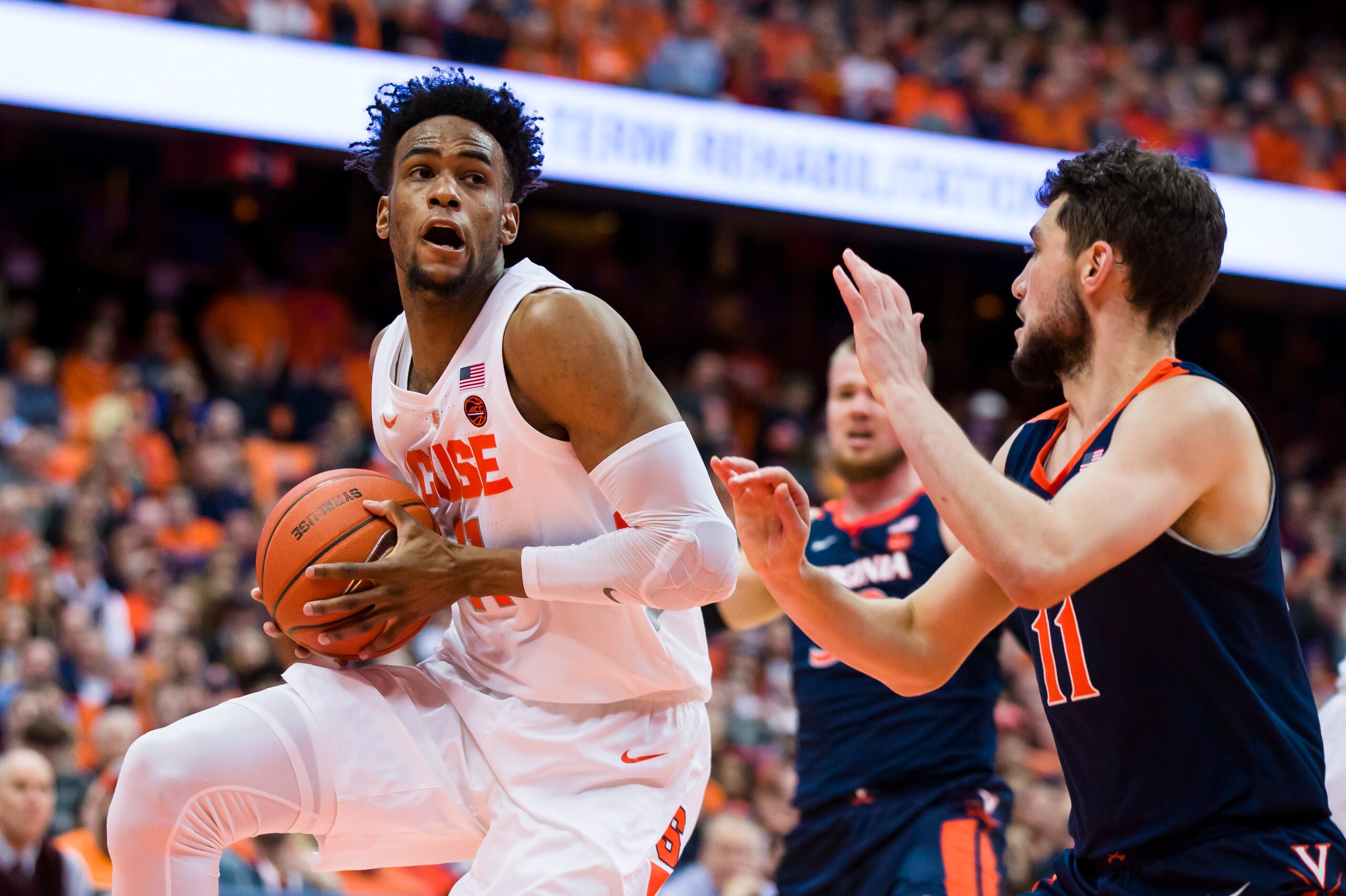 SYRACUSE, NY - MARCH 04:  Oshae Brissett #11 of the Syracuse Orange drives to the basket against Ty Jerome #11 of the Virginia Cavaliers during the second half at the Carrier Dome on March 4, 2019 in Syracuse, New York. Virginia defeats Syracuse 79-53.  (