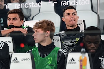 Juventus' Portuguese forward Cristiano Ronaldo (Rear R) and Juventus' Argentine forward Paulo Dybala (L) sit in the substitutes area prior to the Italian Serie A football match Juventus vs Udinese on March 8, 2019 at the Juventus Allianz stadium in Turin.