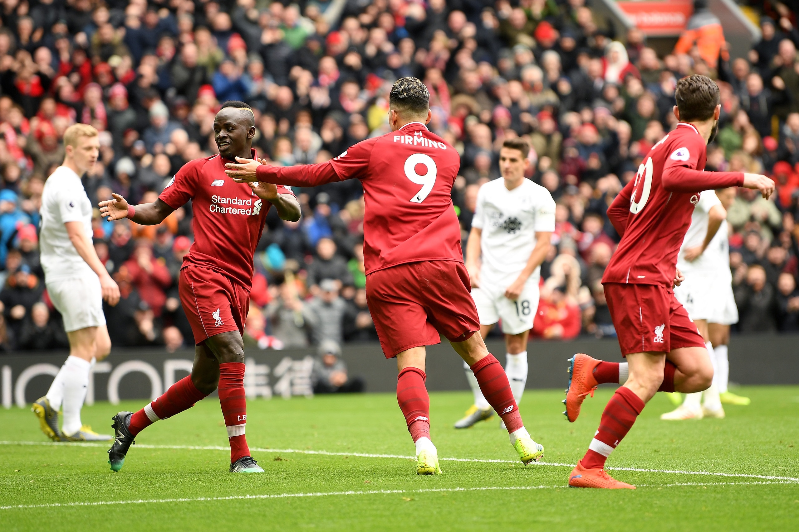 LIVERPOOL, ENGLAND - MARCH 10: Roberto Firmino of Liverpool celebrates with Sadio Mane of Liverpool after scoring his sides first goal during the Premier League match between Liverpool FC and Burnley FC at Anfield on March 10, 2019 in Liverpool, United Ki