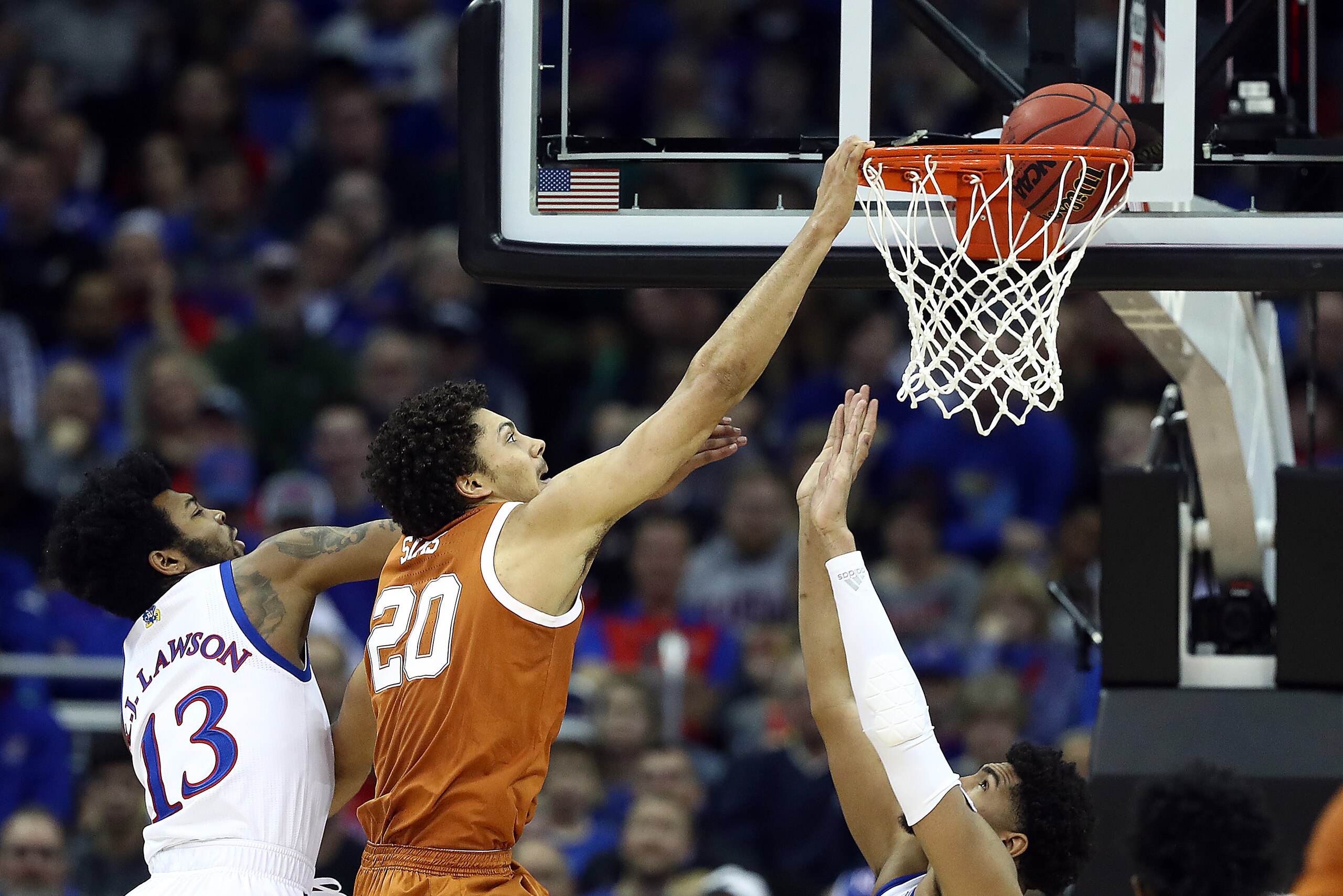 KANSAS CITY, MISSOURI - MARCH 14:  Jericho Sims #20 of the Texas Longhorns dunks as K.J. Lawson #13 of the Kansas Jayhawks defends during the quarterfinal game of the Big 12 Basketball Tournament at Sprint Center on March 14, 2019 in Kansas City, Missouri