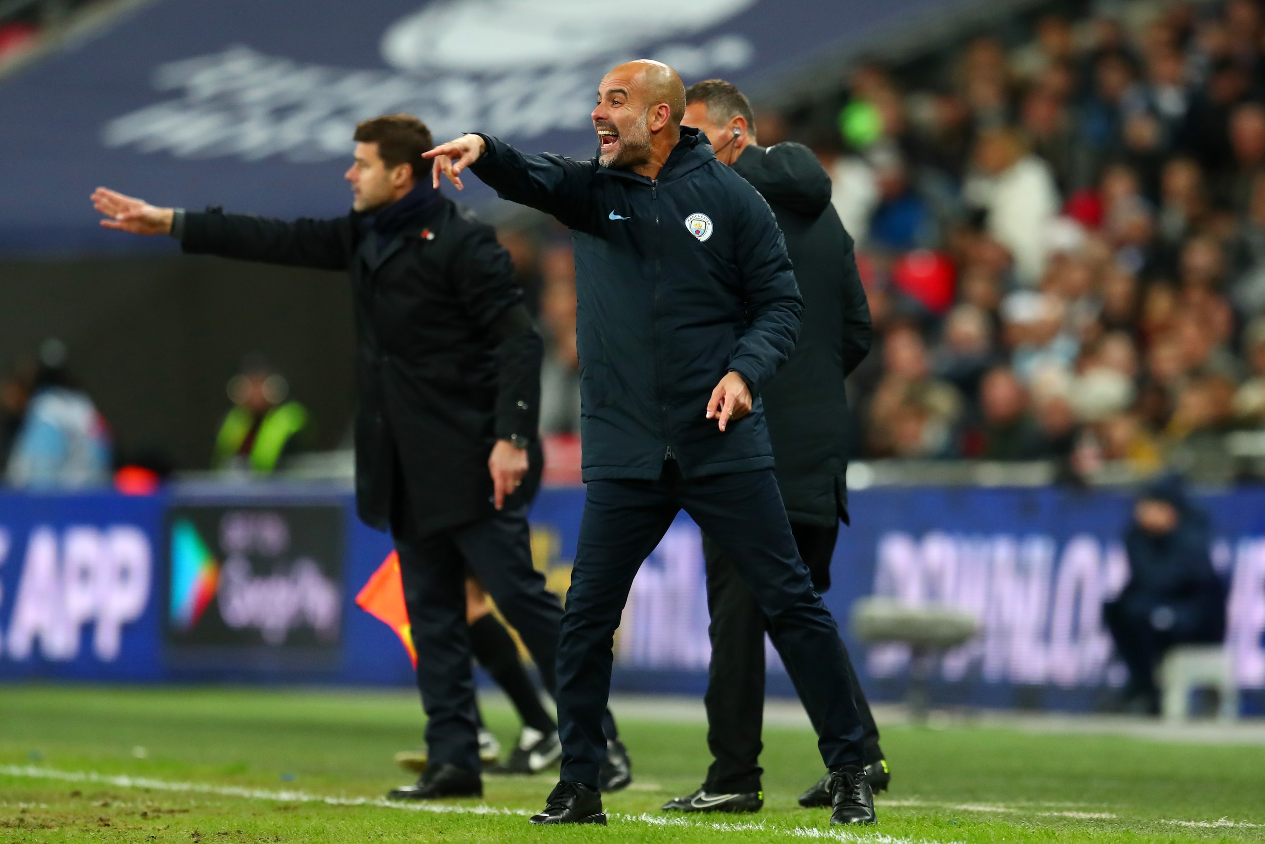 LONDON, ENGLAND - OCTOBER 29:  Josep Guardiola, Manager of Manchester City and Mauricio Pochettino, Manager of Tottenham Hotspur give their teams instructions during the Premier League match between Tottenham Hotspur and Manchester City at Wembley Stadium