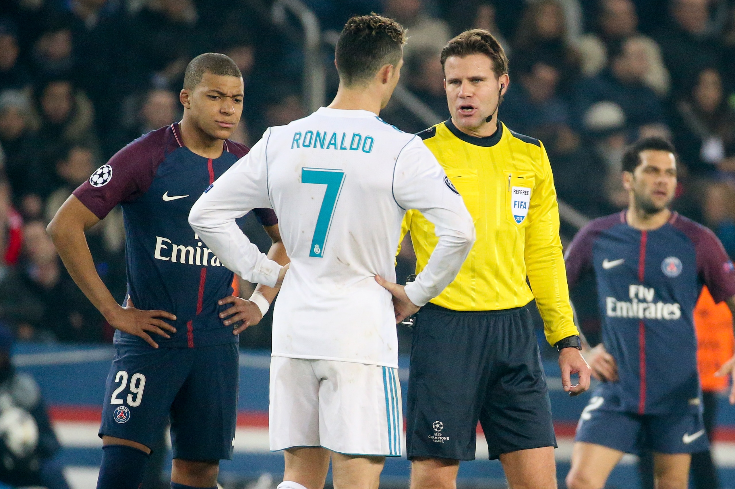 PARIS, FRANCE - MARCH 6: Referee Felix Brych of Germany talks to Cristiano Ronaldo of Real Madrid while Kylian Mbappe of PSG looks on during the UEFA Champions League Round of 16 Second Leg match between Paris Saint-Germain (PSG) and Real Madrid at Parc d