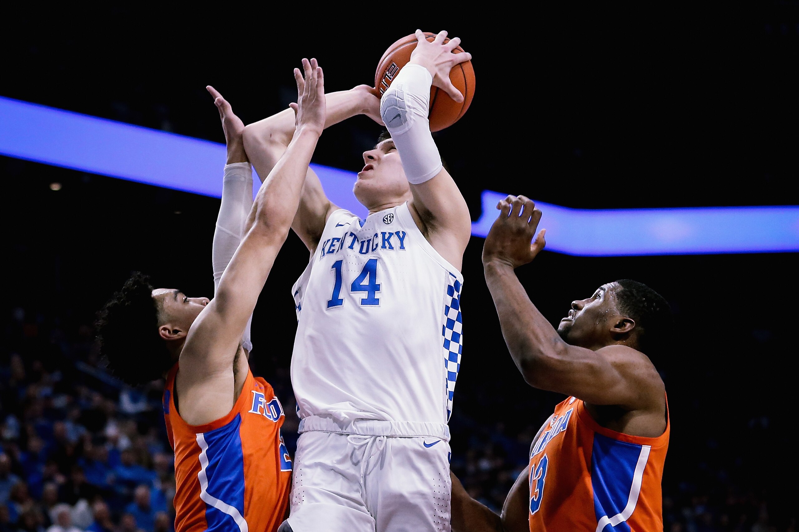 LEXINGTON, KENTUCKY - MARCH 09:  Tyler Herro #14 of the Kentucky Wildcats attempts a shot while being guarded by Andrew Nembhard #2 and Kevarrius Hayes #13 of the Florida Gators in the first half at Rupp Arena on March 09, 2019 in Lexington, Kentucky. (Ph