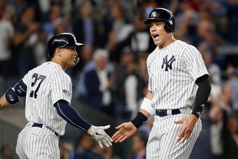 NEW YORK, NY - OCTOBER 03:  (NEW YORK DAILIES OUT)   Aaron Judge #99 and Giancarlo Stanton #27 of the New York Yankees during the sixth inning against the Oakland Athletics in the American League Wild Card Game at Yankee Stadium on October 3, 2018 in the 