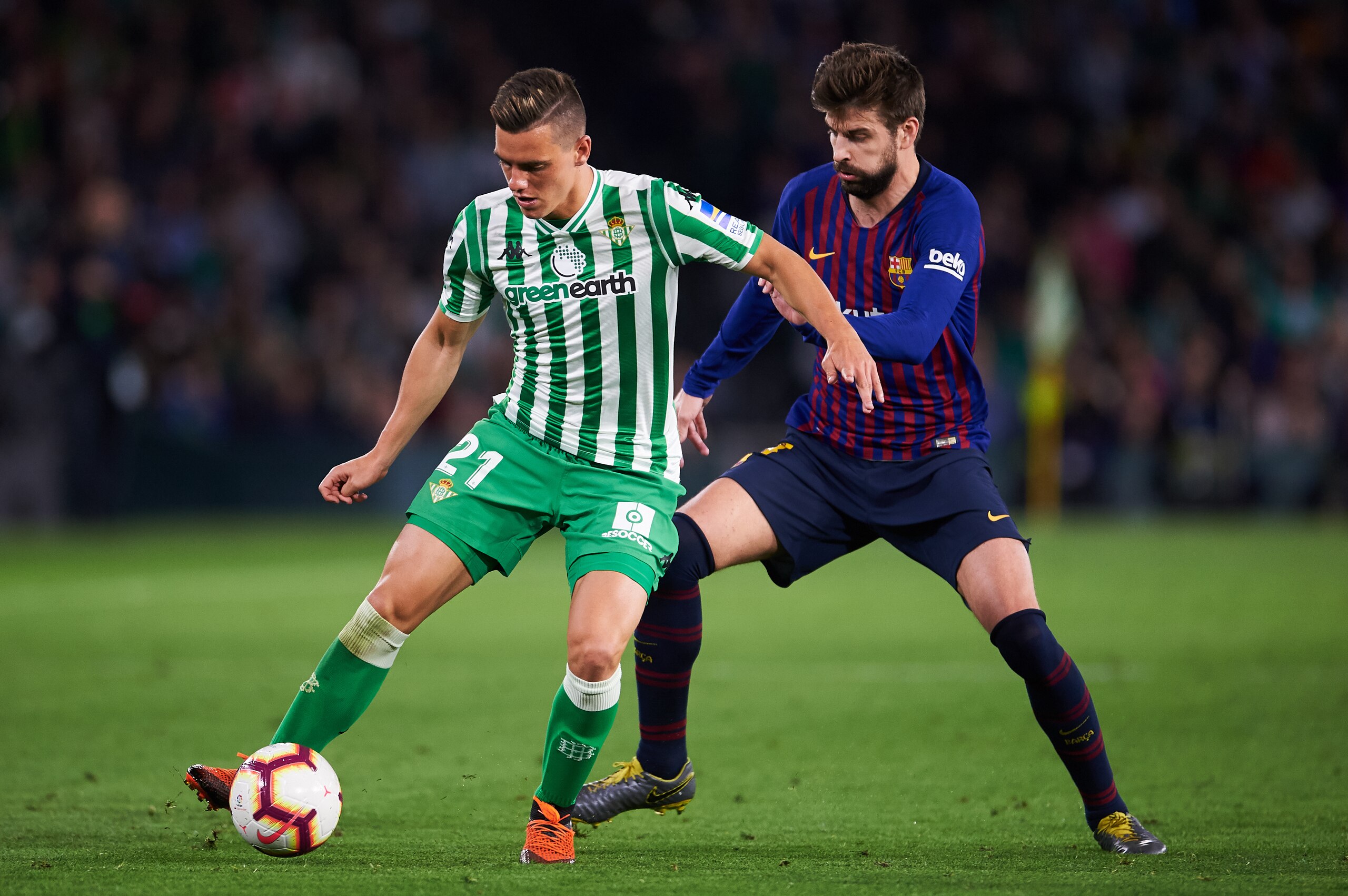 SEVILLE, SPAIN - MARCH 17: Gerard Pique of FC Barcelona duels for the ball with Giovani Lo Celso of Real Betis Balompie during the La Liga match between Real Betis Balompie and FC Barcelona at Estadio Benito Villamarin on March 17, 2019 in Seville, Spain.