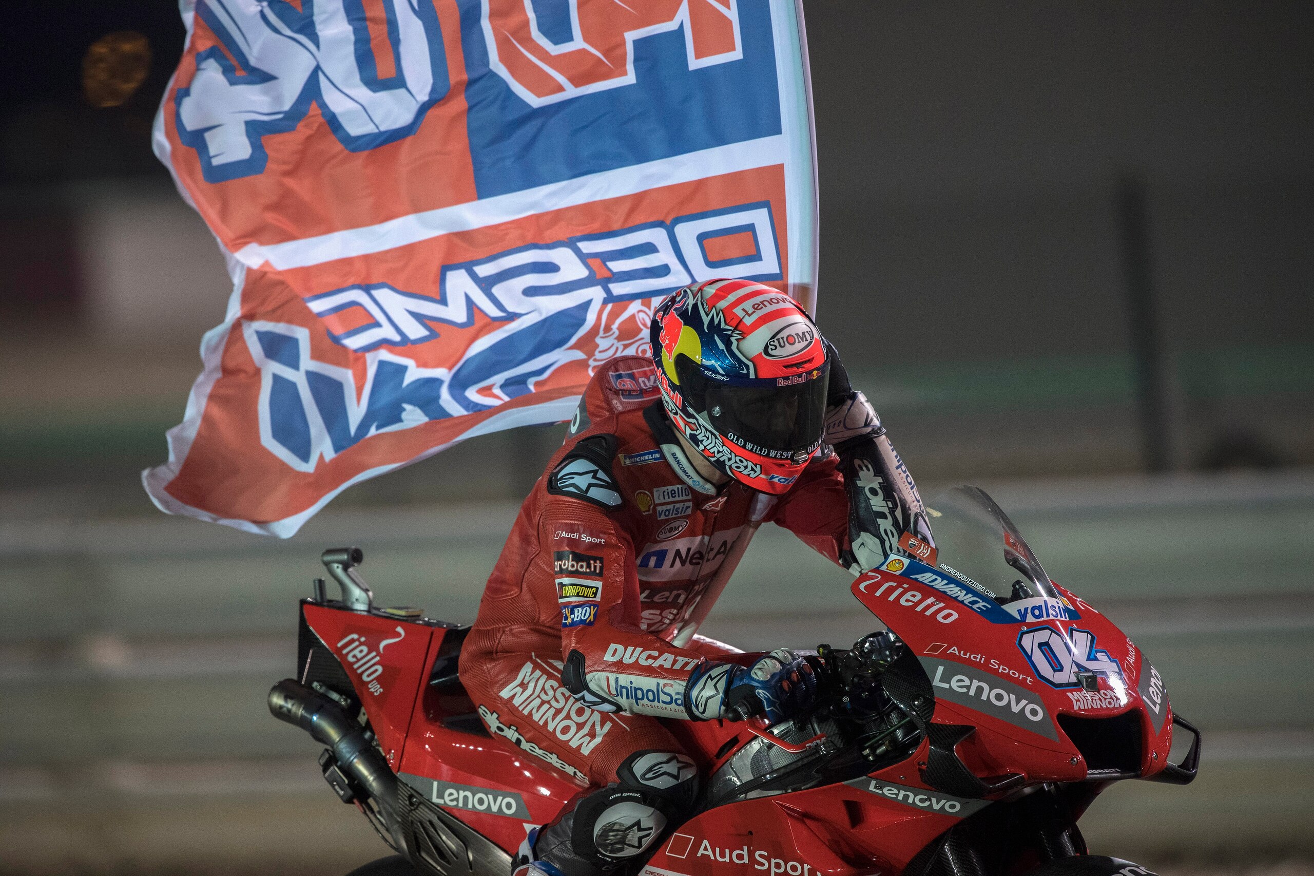 DOHA, QATAR - MARCH 10:  Andrea Dovizioso of Italy and Ducati Team  celebrates with flag the victory at the end of the MotoGP race  during the MotoGP of Qatar - Race at Losail Circuit on March 10, 2019 in Doha, Qatar. (Photo by Mirco Lazzari gp/Getty Imag