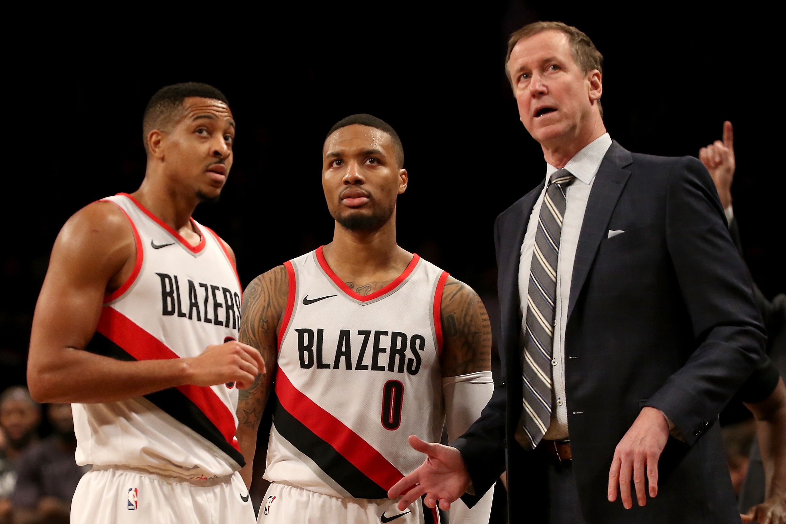 NEW YORK, NY - NOVEMBER 24: CJ McCollum #3 (L), Damian Lillard #0 and Terry Stotts of the Portland Trail Blazers talk late in the fourth quarter against the Brooklyn Nets at Barclays Center on November 24, 2017 in the Brooklyn borough of New York City. NO