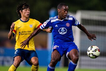 HONG KONG, HONG KONG - FEBRUARY 28: Rohan Anthony Ricketts (R) of Eastern competes the ball with Kwan Yee Lo (L) of Kitchee  FC during the HKFA Premier League between Eastern and Kitchee FC at the Tseung Kwan O Sports Ground on 28 February 2015 in Hong Ko