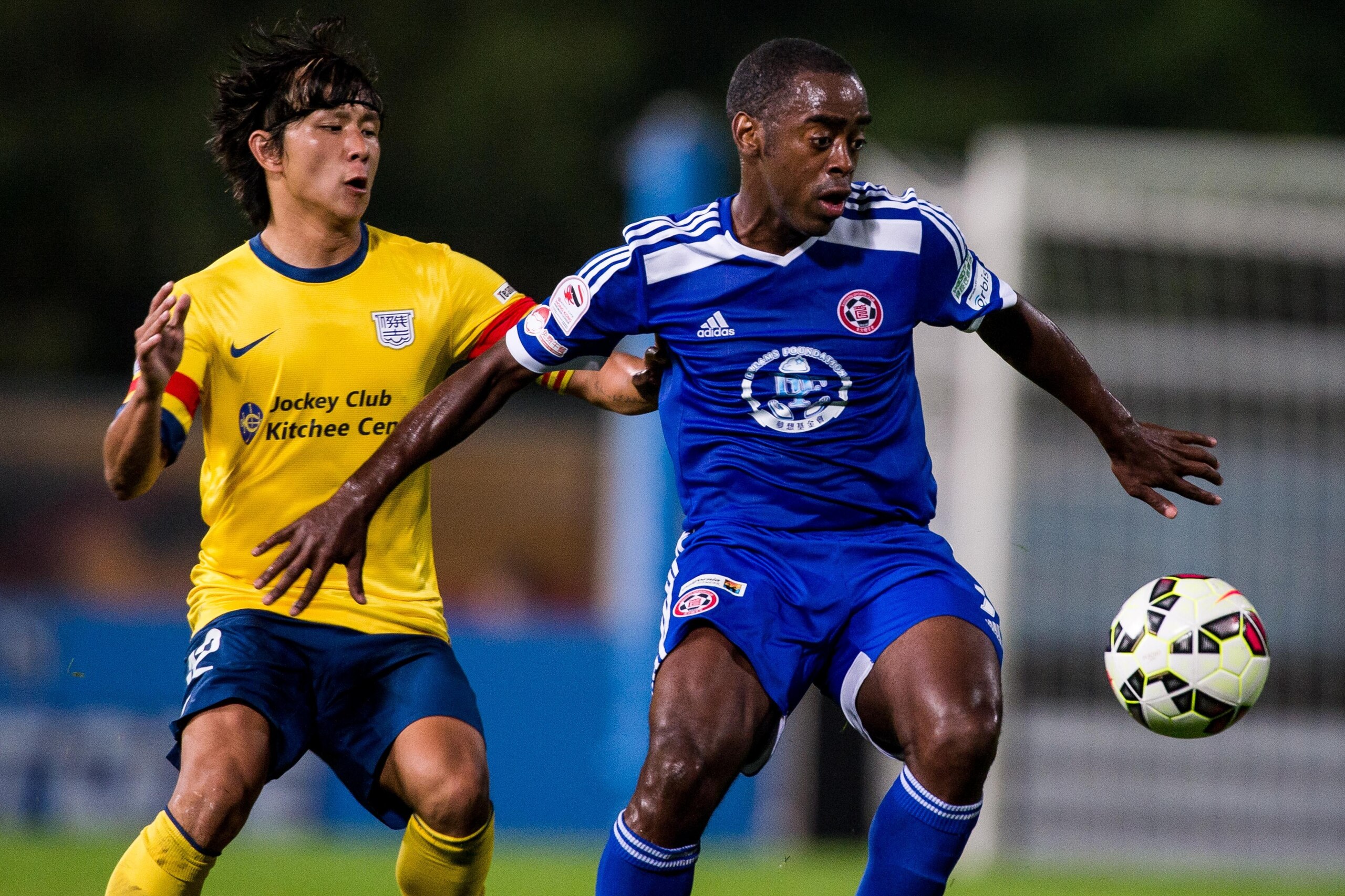 HONG KONG, HONG KONG - FEBRUARY 28: Rohan Anthony Ricketts (R) of Eastern competes the ball with Kwan Yee Lo (L) of Kitchee  FC during the HKFA Premier League between Eastern and Kitchee FC at the Tseung Kwan O Sports Ground on 28 February 2015 in Hong Ko