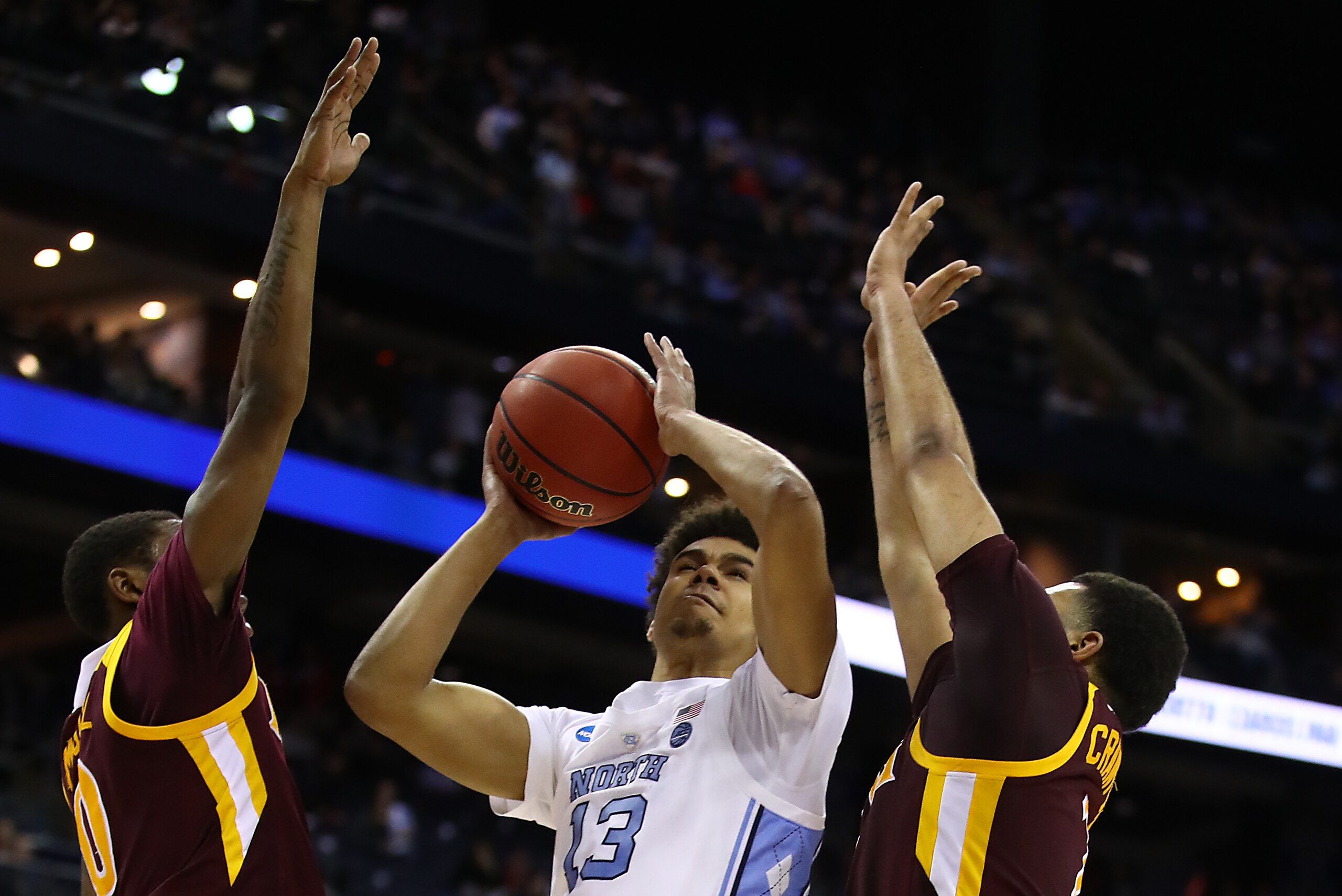 COLUMBUS, OHIO - MARCH 22:  Cameron Johnson #13 of the North Carolina Tar Heels shoots against E.J. Crawford #2 and Rickey McGill #0 of the Iona Gaels during the second half of the game in the first round of the 2019 NCAA Men's Basketball Tournament at Na