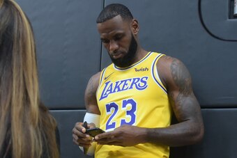 LeBron James checks his cellphone on arrival for his press conference on the Los Angeles Lakers in Los Angeles, California, September 24, 2018, with the Lakers' newest blockbuster signing and teammates met with the media. - The Lakers open their 2018 NBA 