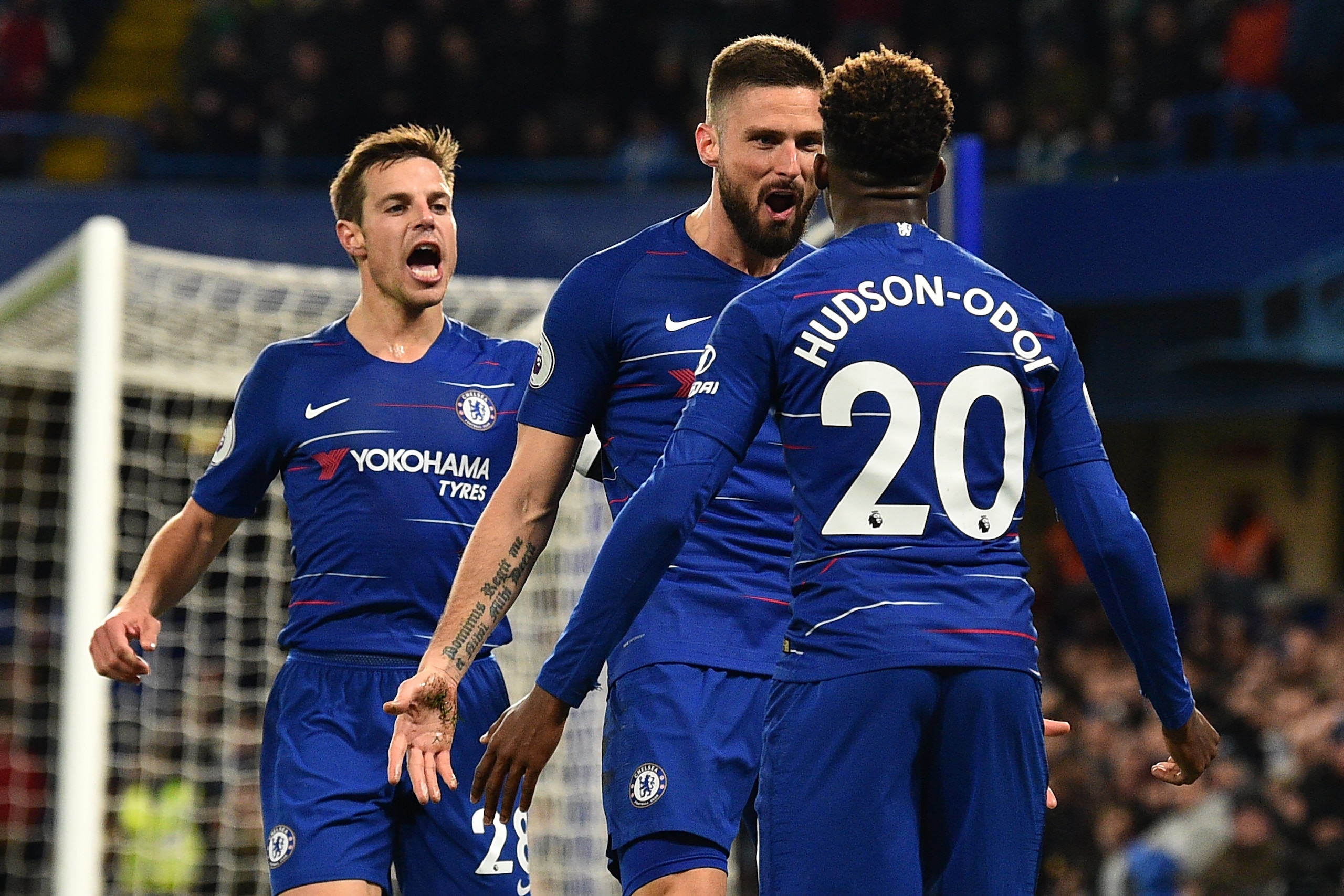 Chelsea's French striker Olivier Giroud (C) celebrates with Chelsea's Spanish defender Cesar Azpilicueta (L) and Chelsea's English midfielder Callum Hudson-Odoi (R) after scoring the opening goal of the English Premier League football match between Chelse