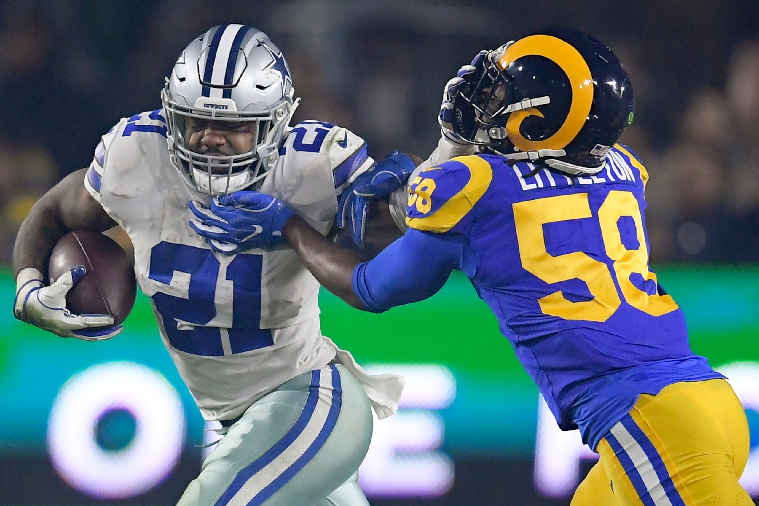 Dallas Cowboys running back Ezekiel Elliott throws a stiff-arm on Los Angeles Rams linebacker Cory Littleton. Dallas Cowboys running back Ezekiel Elliott throws a stiff-arm on Los Angeles Rams linebacker Cory Littleton.