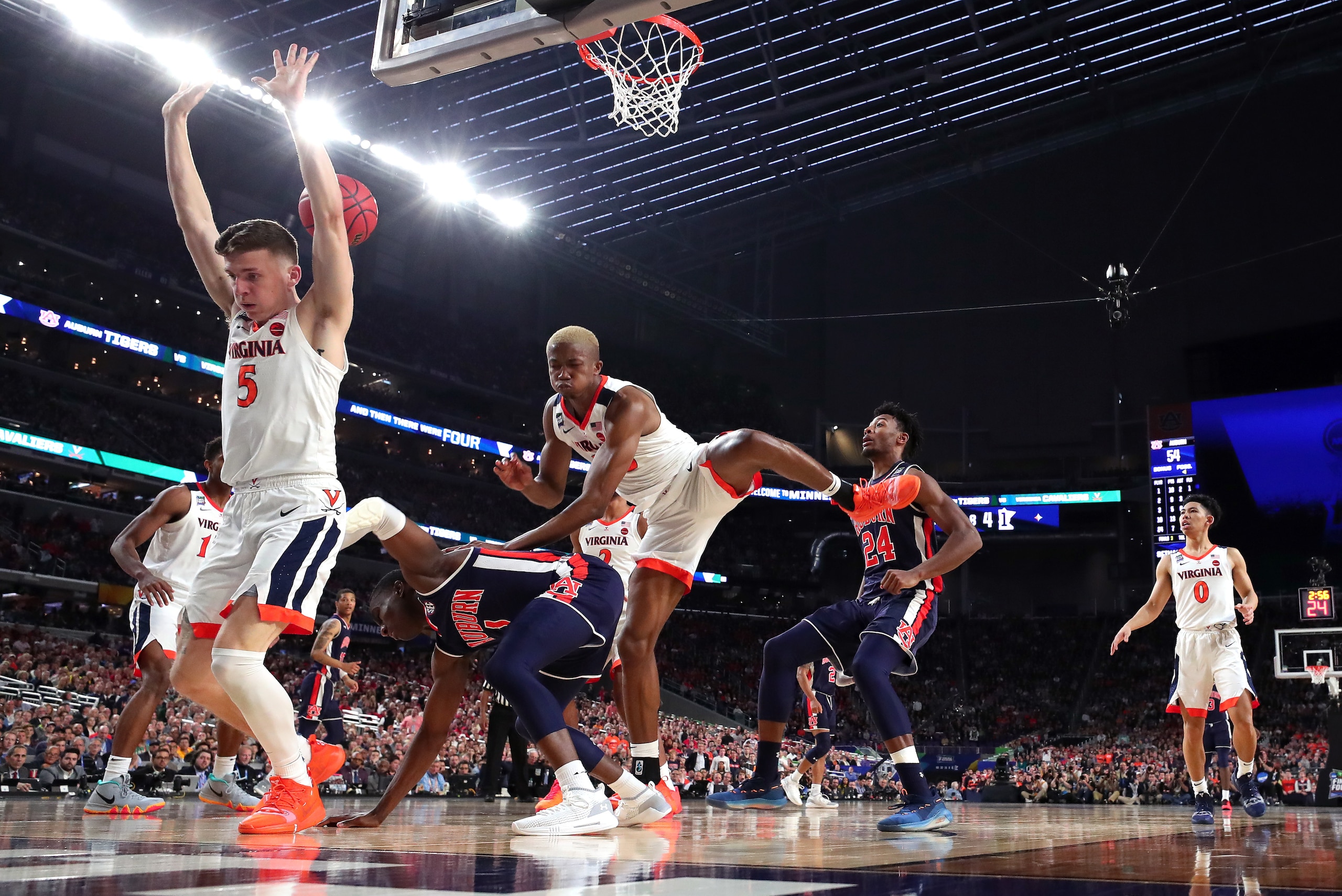 MINNEAPOLIS, MINNESOTA - APRIL 06: Jared Harper #1 of the Auburn Tigers falls down as he is defended by Kyle Guy #5 and Mamadi Diakite #25 of the Virginia Cavaliers in the second half during the 2019 NCAA Final Four semifinal at U.S. Bank Stadium on April