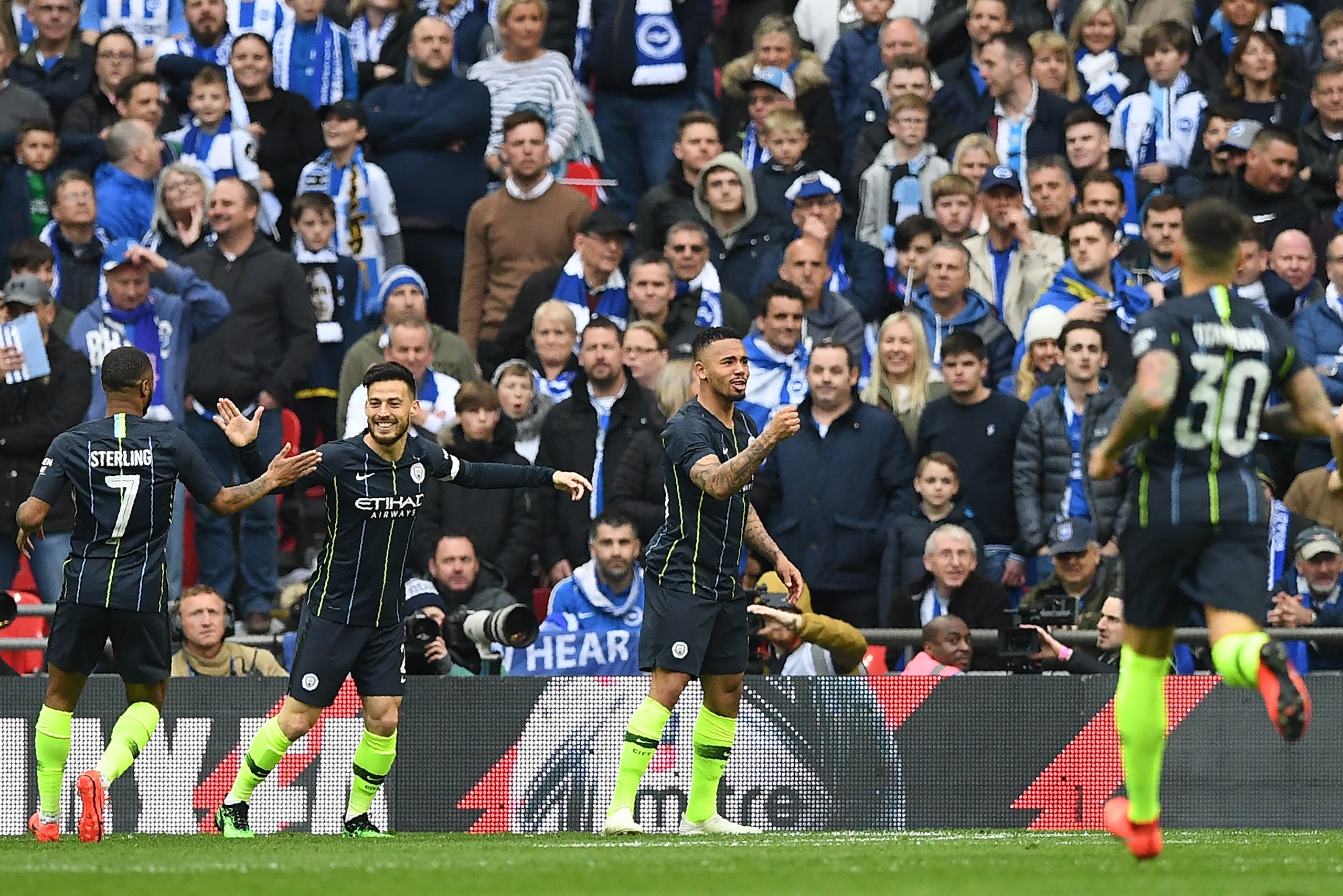 Manchester City's Brazilian striker Gabriel Jesus (2R) celebrates after scoring the team's first goal during the English FA Cup semi-final football match between Manchester City and Brighton and Hove Albion at Wembley Stadium in London, on April 6, 2019. 