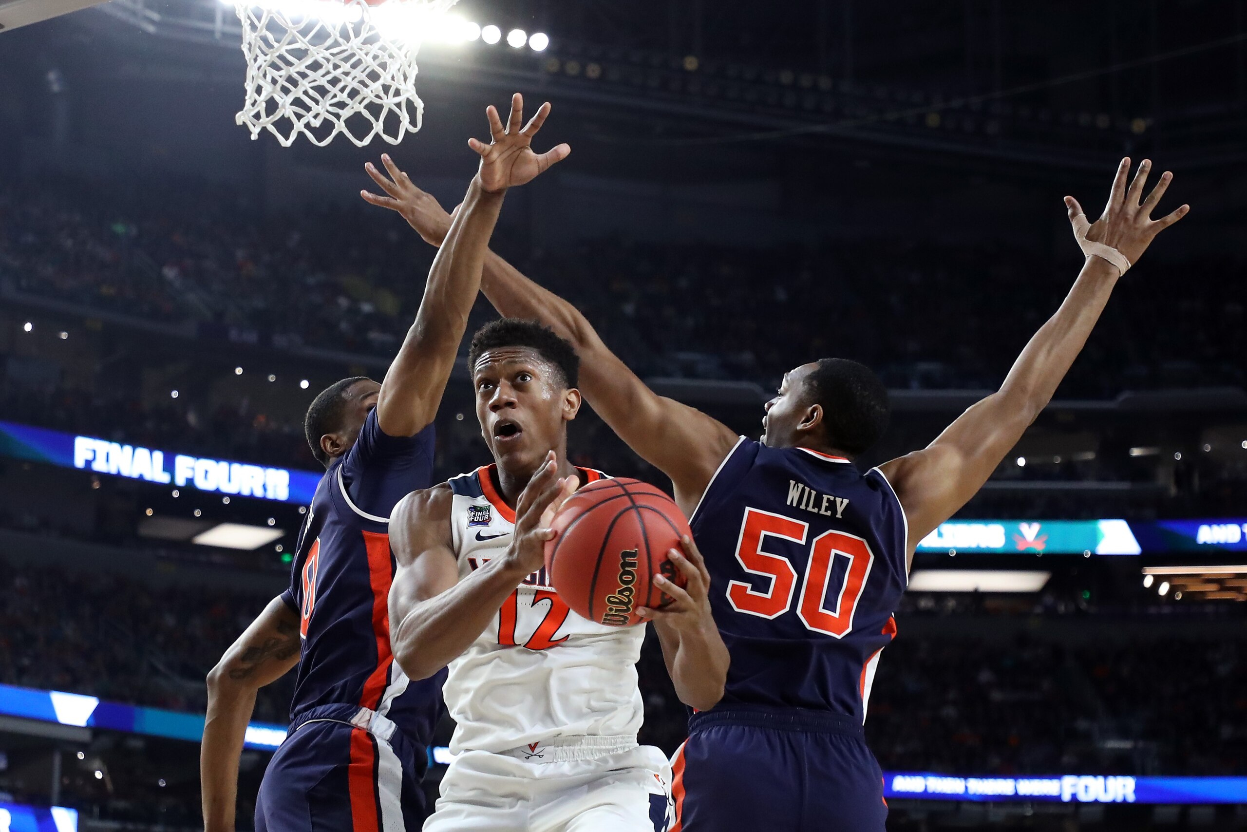 MINNEAPOLIS, MINNESOTA - APRIL 06: De'Andre Hunter #12 of the Virginia Cavaliers drives to the basket against Horace Spencer #0 and Austin Wiley #50 of the Auburn Tigers in the second half during the 2019 NCAA Final Four semifinal at U.S. Bank Stadium on 