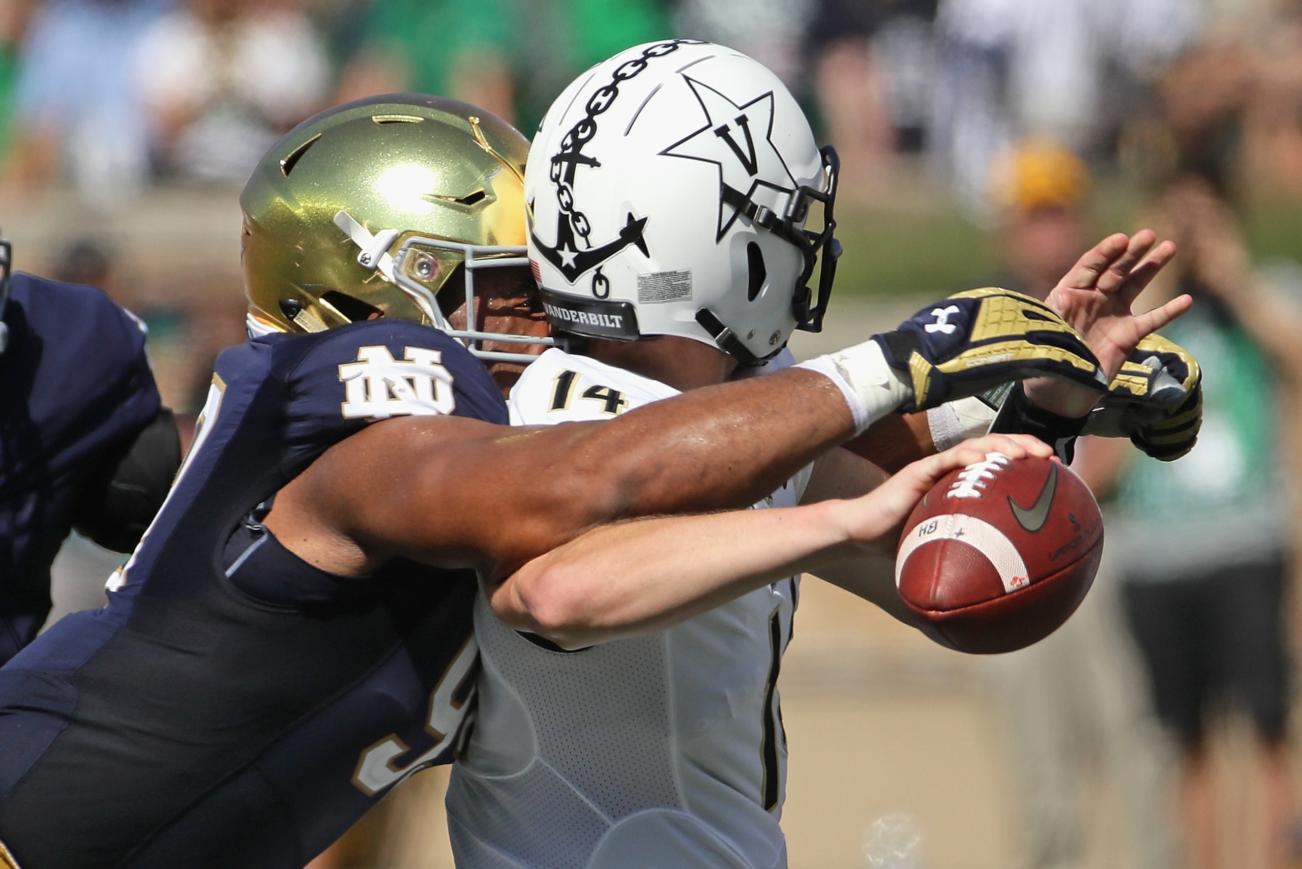 SOUTH BEND, IN - SEPTEMBER 15:  Jerry Tillery #99 of the Notre Dame Fighting Irish hits Kyle Shurmur #14 of the Vanderbilt Commodores as he passes forcing a fumble at Notre Dame Stadium on September 15, 2018 in South Bend, Indiana.  (Photo by Jonathan Dan