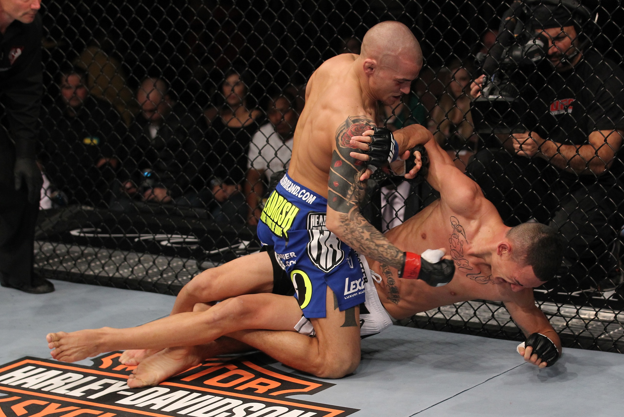 LAS VEGAS, NV - FEBRUARY 04:  Dustin Poirier (blue shorts) delivers punches to Max Holloway from the mount during the UFC 143 event at Mandalay Bay Events Center on February 4, 2012 in Las Vegas, Nevada.  (Photo by Nick Laham/Zuffa LLC/Zuffa LLC via Getty