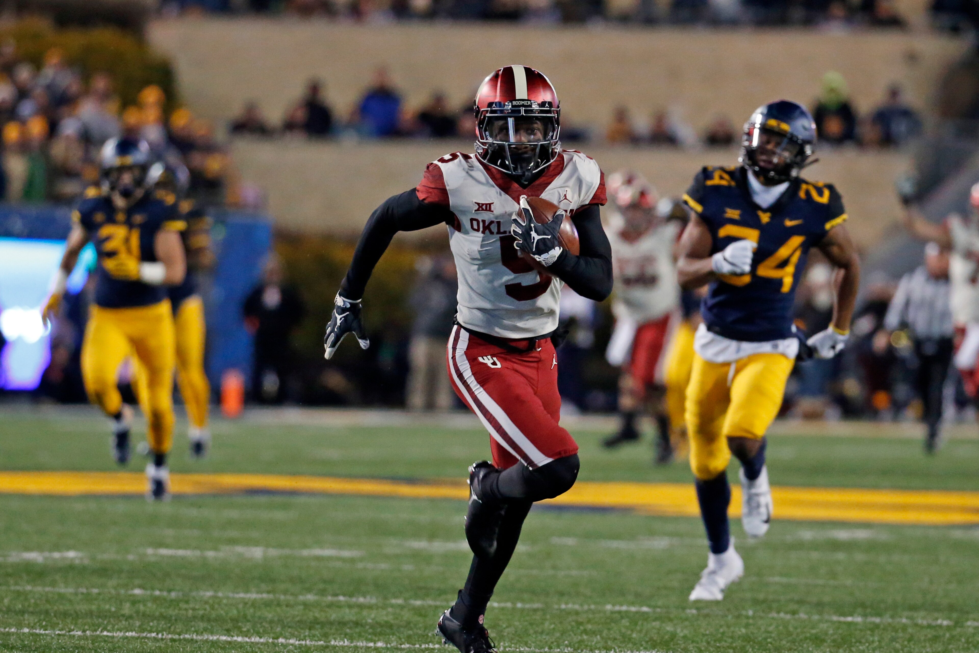 MORGANTOWN, WV - NOVEMBER 23:  Marquise Brown #5 of the Oklahoma Sooners runs after catching a 65 yard pass against the West Virginia Mountaineers on November 23, 2018 at Mountaineer Field in Morgantown, West Virginia.  (Photo by Justin K. Aller/Getty Ima