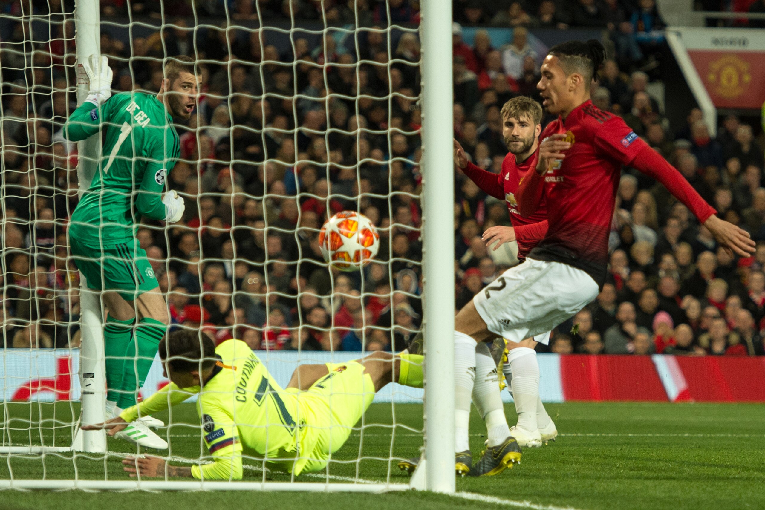 Manchester United's Spanish goalkeeper David de Gea (L) looks on as a shot from Barcelona's Uruguayan forward Luis Suarez strikes Manchester United's English defender Luke Shaw (2R) and is awarded as an own goal during the UEFA Champions league first leg 