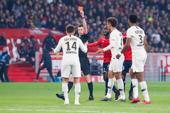 LILLE, FRANCE - APRIL 14: The referee Benoit Bastien gives a red card to Juan Bernat Velasco #14 of Paris Saint-Germain during the Ligue 1 match between Paris Saint-Germain and Lille OSC at Stade Pierre Mauroy on April 14, 2019 in Lille, France. (Photo by
