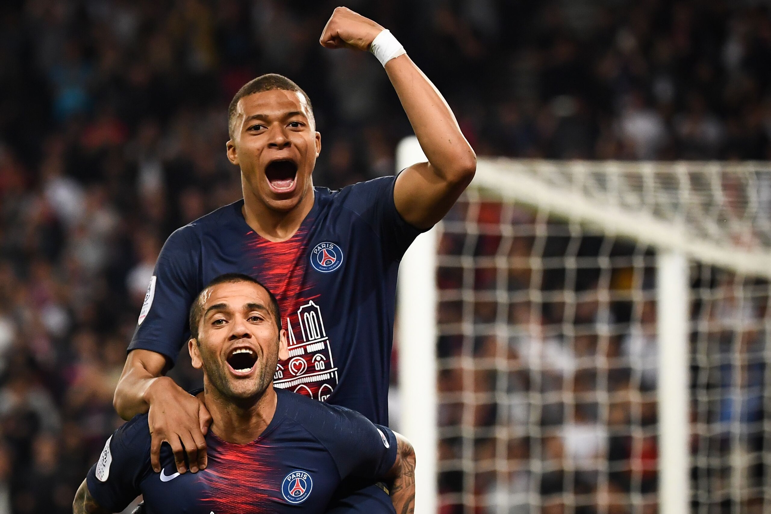 Paris Saint-Germain's Brazilian defender Dani Alves (bot) and Paris Saint-Germain's French forward Kylian Mbappe celebrate after scoring a third goal during the French L1 football match between Paris Saint-Germain (PSG) and Monaco (ASM) on April 21, 2019 