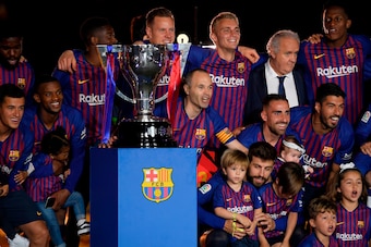Barcelona's Spanish midfielder Andres Iniesta (C) poses with teammates and the Liga trophy during a tribute at the end of the Spanish league football match between FC Barcelona and Real Sociedad at the Camp Nou stadium in Barcelona on May 20, 2018. - Inie