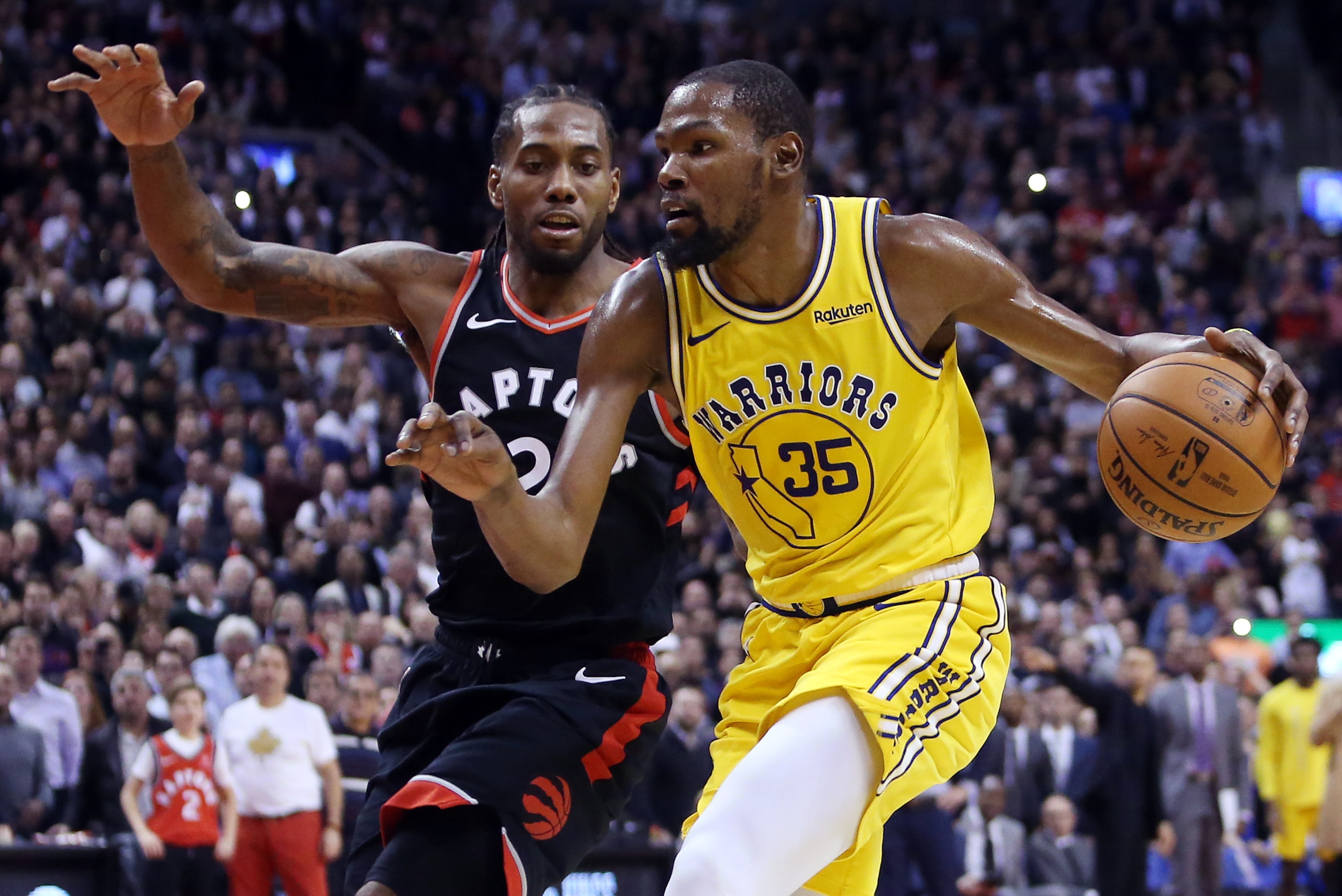TORONTO, ON - NOVEMBER 29:  Kevin Durant #35 of the Golden State Warriors dribbles the ball as Kawhi Leonard #2 of the Toronto Raptors defends during the second half of an NBA game at Scotiabank Arena on November 29, 2018 in Toronto, Canada.  NOTE TO USER