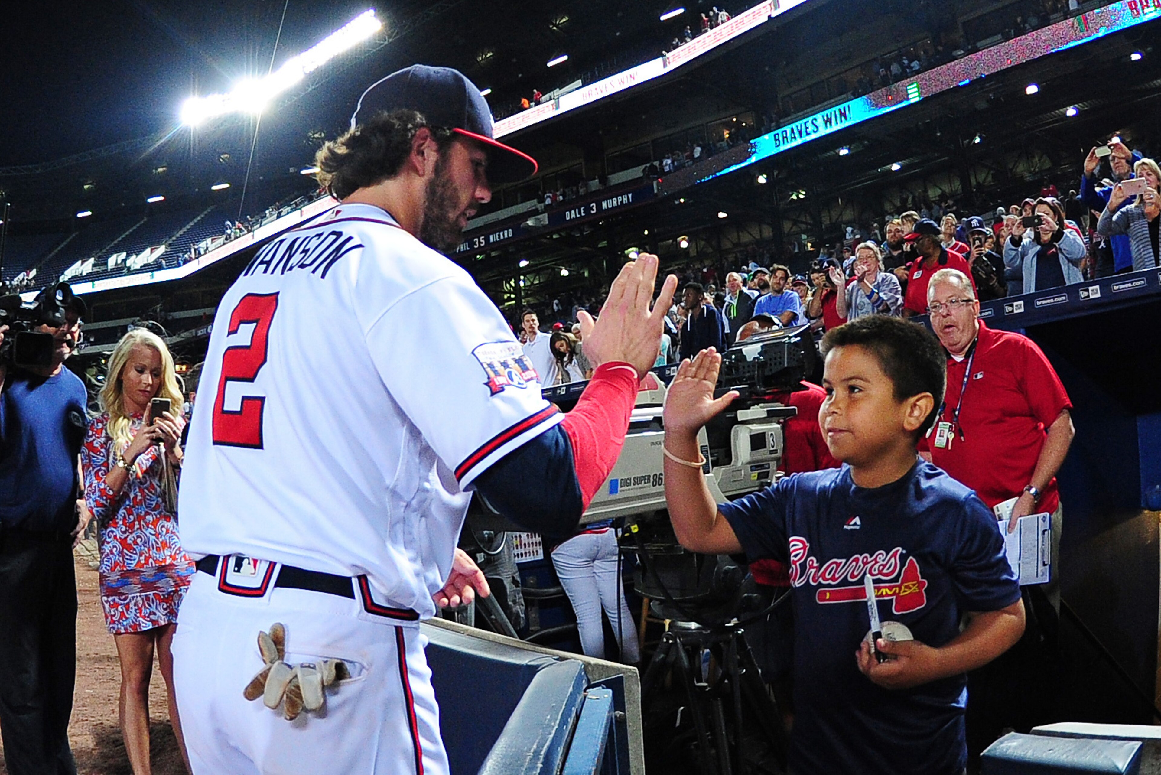 ATLANTA, GA - SEPTEMBER 29: Dansby Swanson #2 of the Atlanta Braves celebrates with a young fan after the game against the Philadelphia Phillies at Turner Field on September 29, 2016 in Atlanta, Georgia. (Photo by Scott Cunningham/Getty Images)