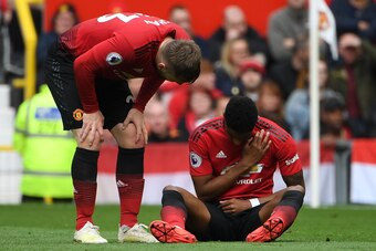 Manchester United's English forward Marcus Rashford (R) gets a attention after taking a knock during the English Premier League football match between Manchester United and Chelsea at Old Trafford in Manchester, north west England, on April 28, 2019. (Pho