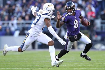 BALTIMORE, MARYLAND - JANUARY 06: Quarterback Lamar Jackson #8 of the Baltimore Ravens stiff arms free safety Derwin James #33 of the Los Angeles Chargers in the second half during the AFC Wild Card Playoff game at M&T Bank Stadium on January 06, 2019 in 