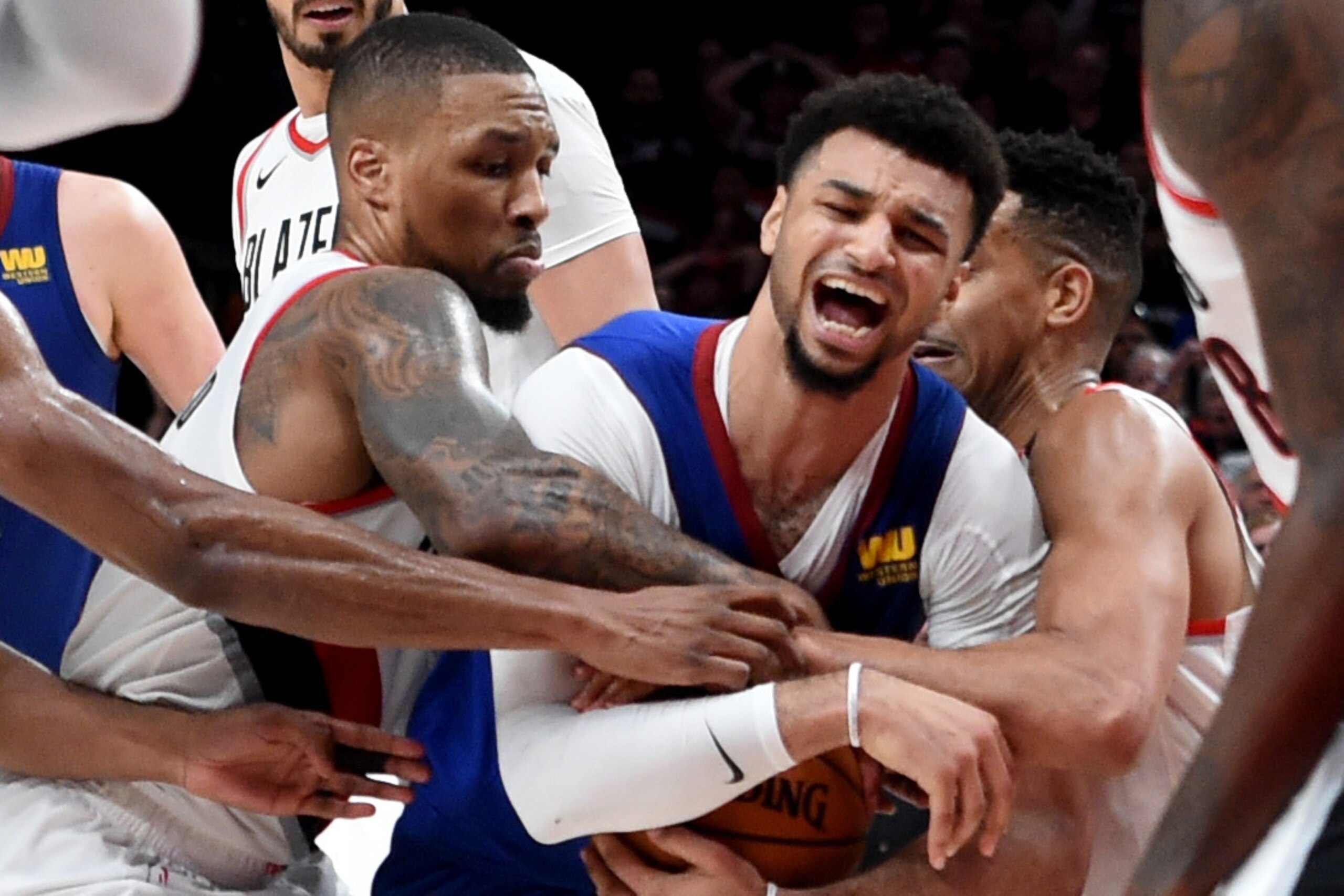 PORTLAND, OREGON - MAY 03: Damian Lillard #0 and CJ McCollum #3 of the Portland Trail Blazers tie up Jamal Murray #27 of the Denver Nuggets during the third overtime of game three of the Western Conference Semifinals at Moda Center on May 03, 2019 in Port PORTLAND, OREGON - MAY 03: Damian Lillard #0 and CJ McCollum #3 of the Portland Trail Blazers tie up Jamal Murray #27 of the Denver Nuggets during the third overtime of game three of the Western Conference Semifinals at Moda Center on May 03, 2019 in Port