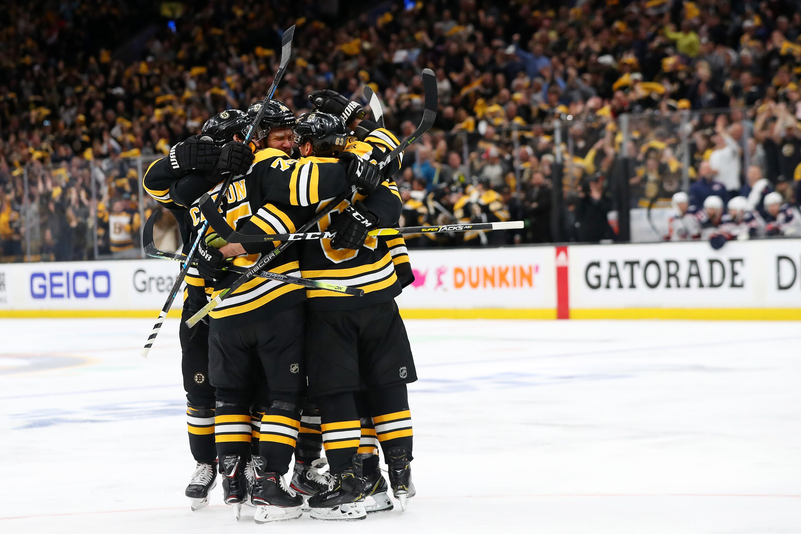 BOSTON, MASSACHUSETTS - MAY 04: Brad Marchand #63 of the Boston Bruins is surrounded by teammates after scoring a goal against the Columbus Blue Jackets during the third period of Game Five of the Eastern Conference Second Round during the 2019 NHL Stanle