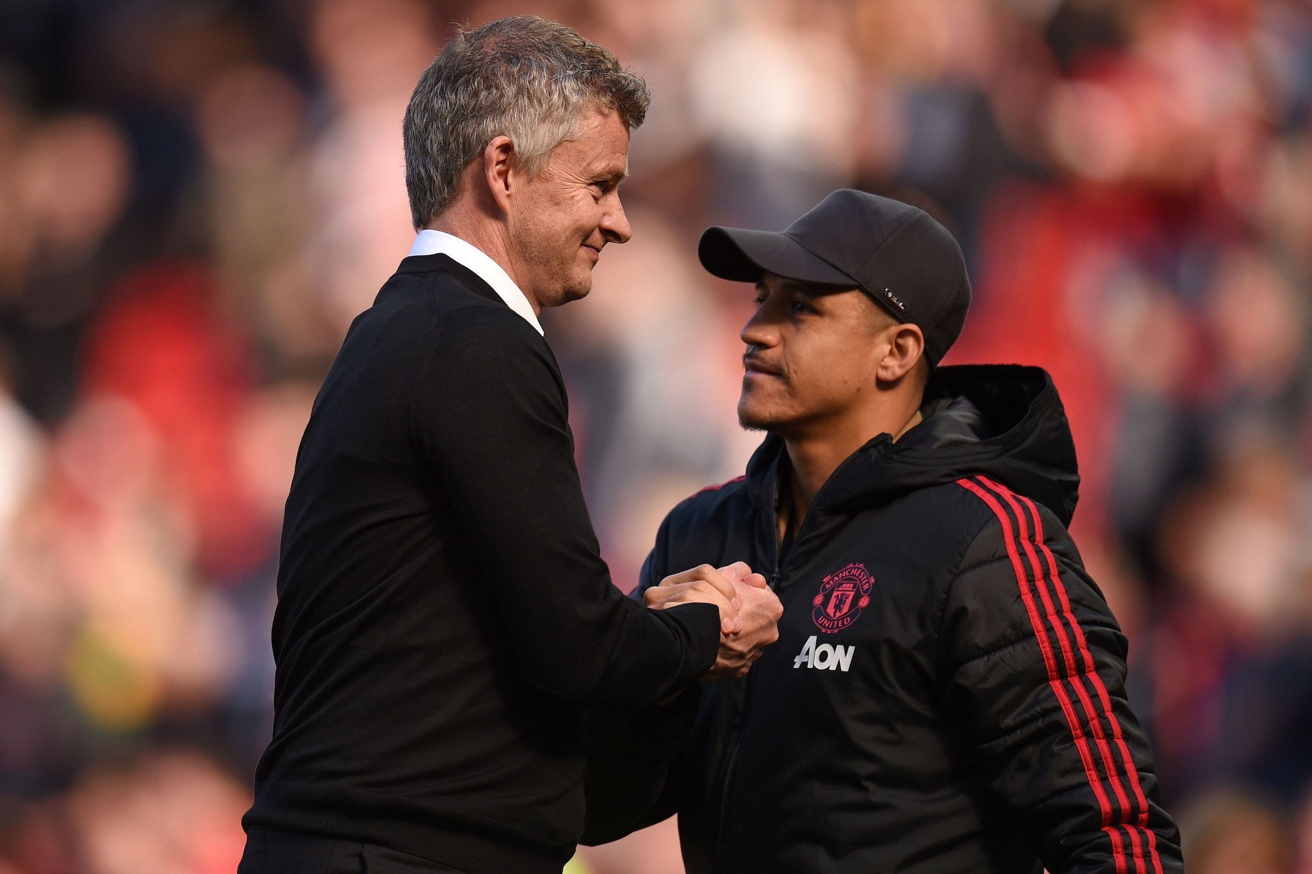 Manchester United's Norwegian manager Ole Gunnar Solskjaer shakes hands with Manchester United's Chilean striker Alexis Sanchez (R) on the pitch after the English Premier League football match between Manchester United and Cardiff City at Old Trafford in 