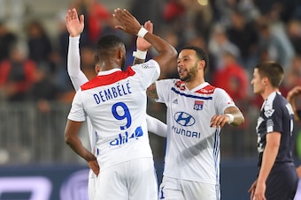 Lyon's French forward Moussa Dembele (L) and Lyon's Dutch forward Memphis Depay (C) celebrate at the end of the French L1 football match between Bordeaux (FCGB) and Lyon (OL) on April 26, 2019 at the Matmut Atlantique stadium in Bordeaux, southwestern Fra